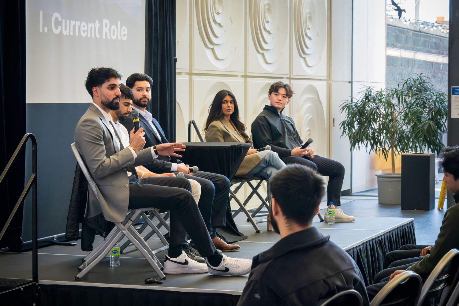 Professional conference setup with panel members seated on stage discussing topics.