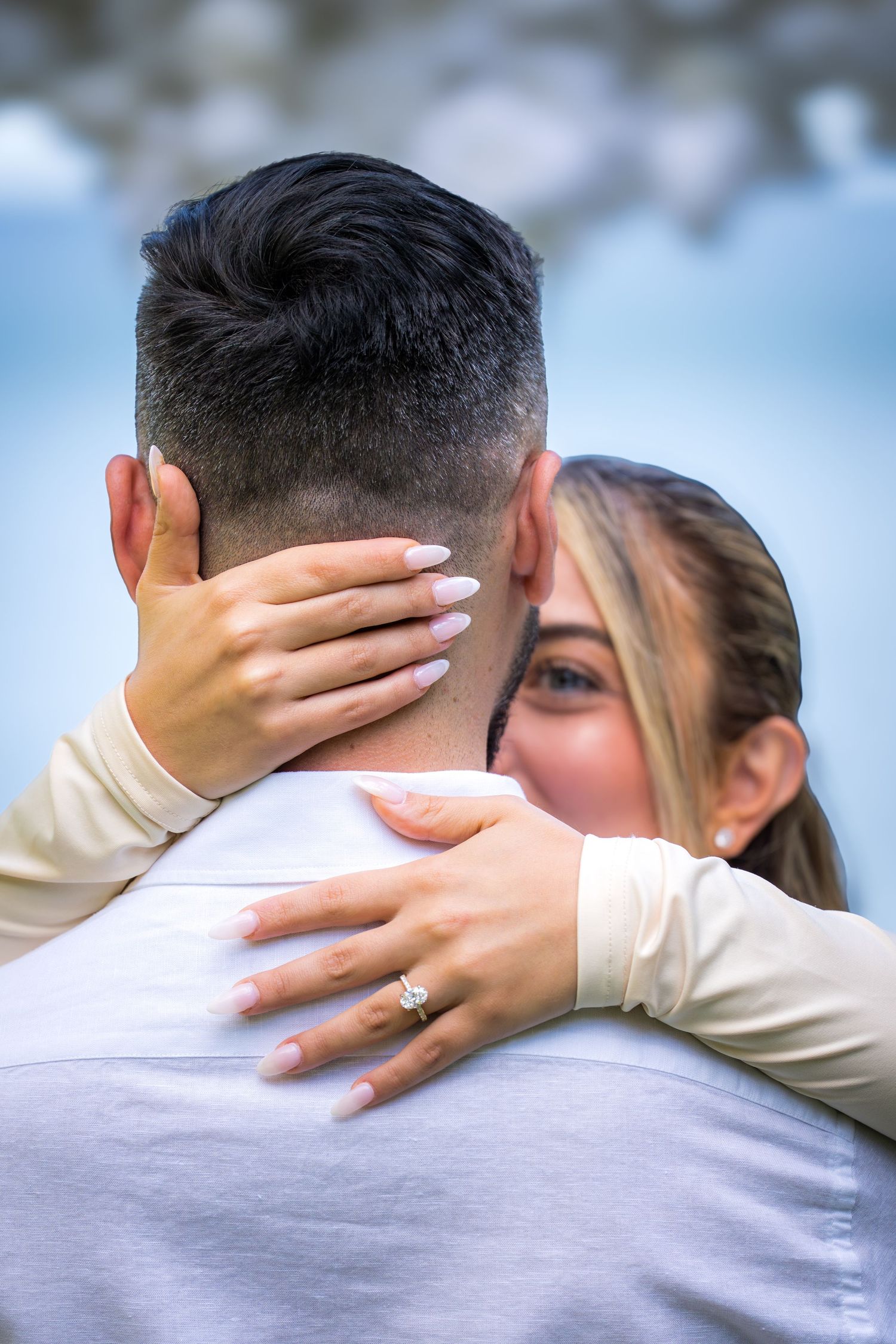 Close-up of tender embrace during outdoor wedding celebration.
