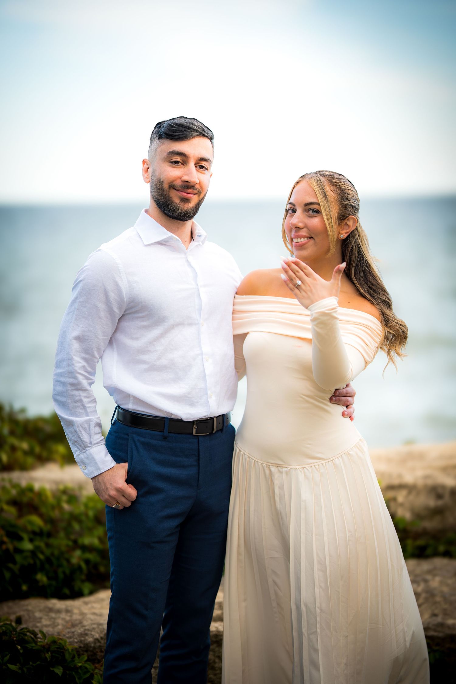 Newlyweds share intimate moments by the ocean during their wedding photoshoot.