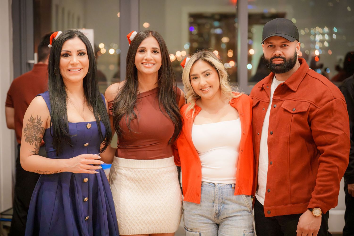 Group of friends posing together at a holiday party in casual attire.