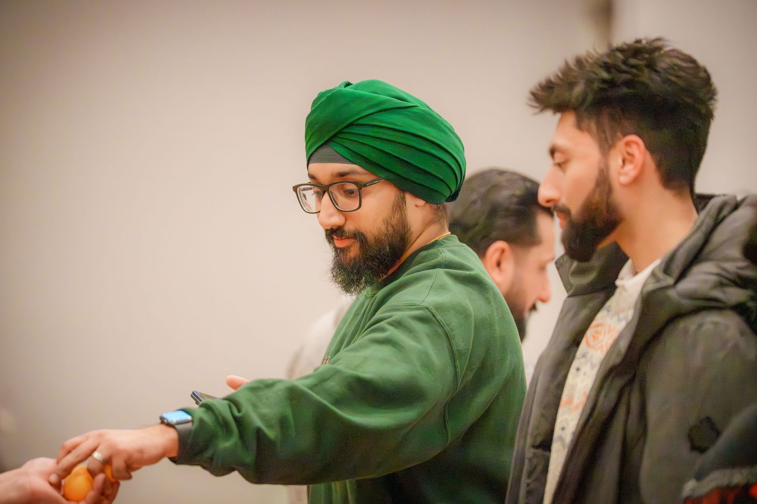 People wearing casual winter attire socializing at an indoor gathering.