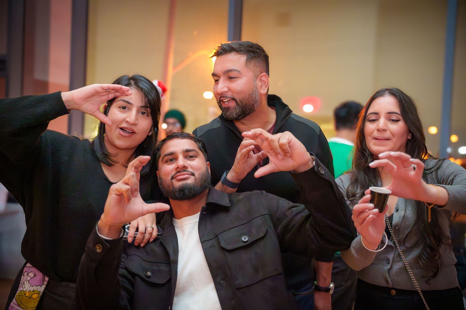 Group sharing laughs and making hand gestures at an indoor party.