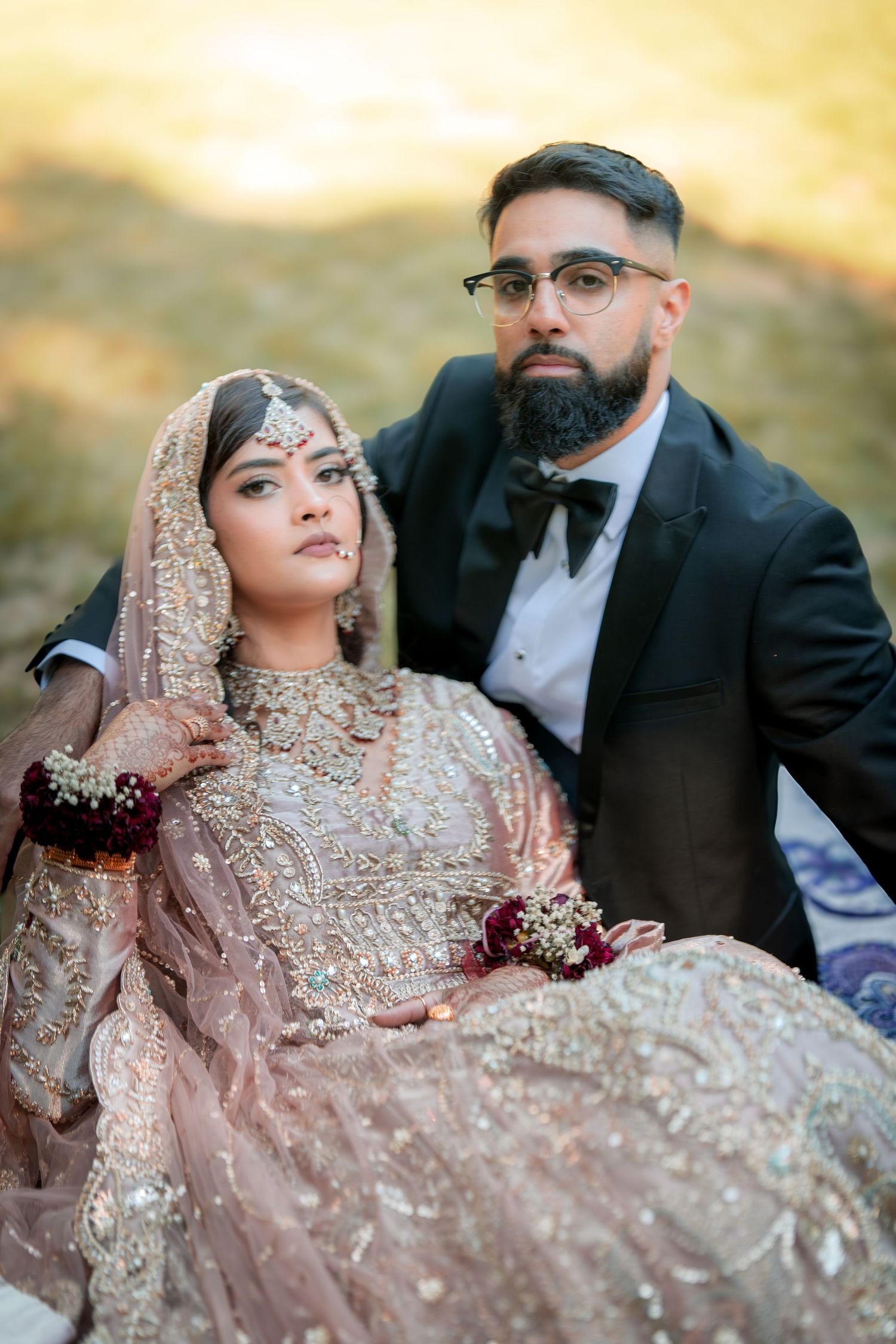Wedding couple in traditional South Asian dress photographed in golden evening light.