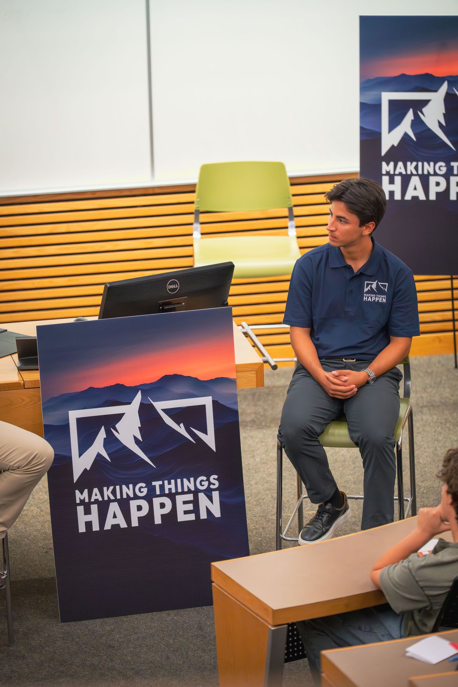 Conference room setup with 'Making Things Happen' branded signage and modern furniture.