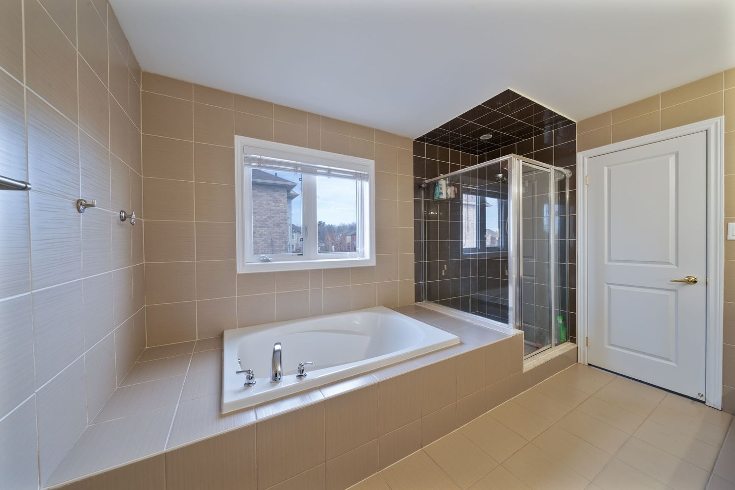 Modern bathroom interior with beige tile walls and white fixtures shown in a panoramic view.