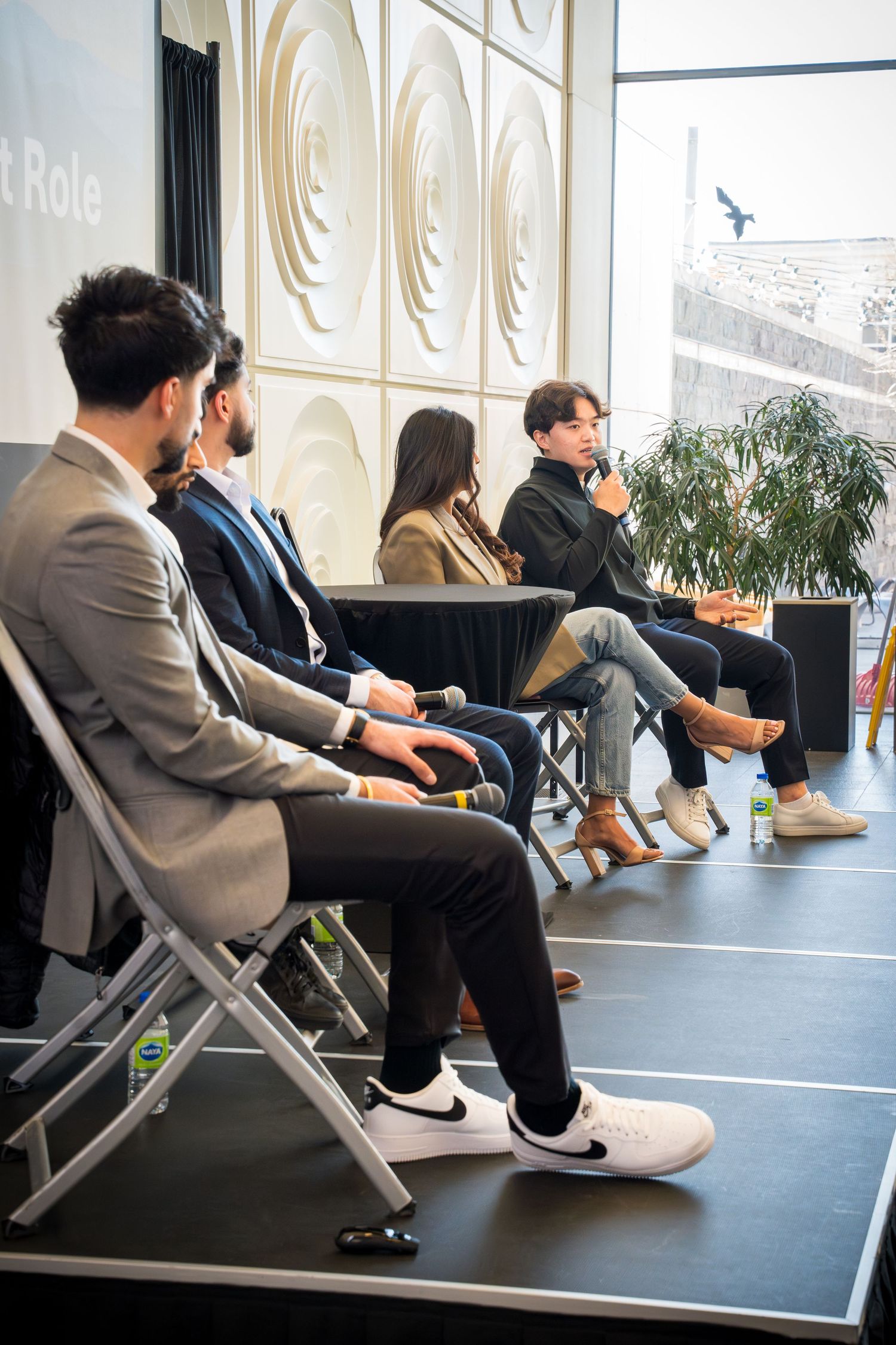 Side view of panel speakers seated on stage during presentation.