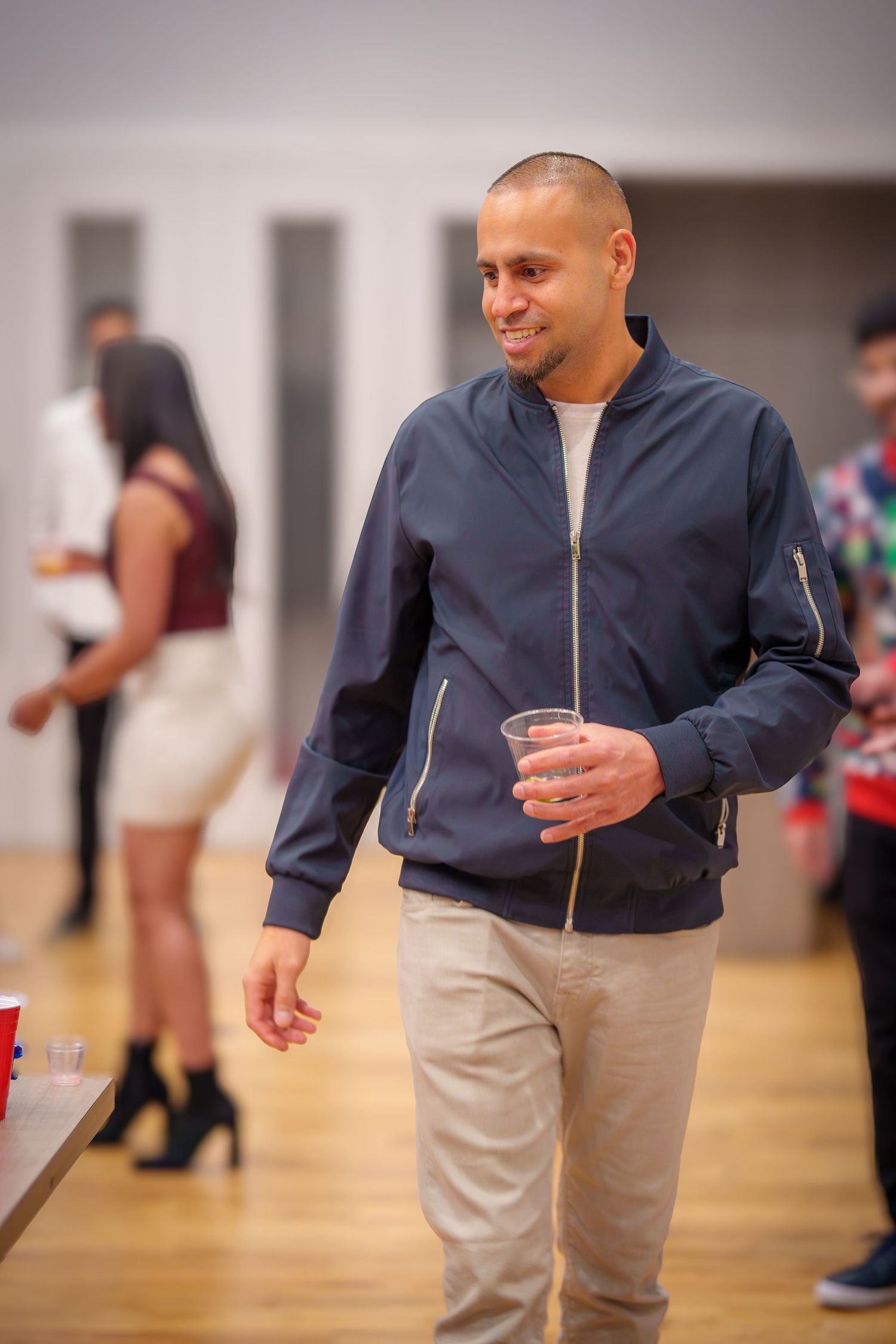 Person in navy jacket and khaki pants participating in a party game.
