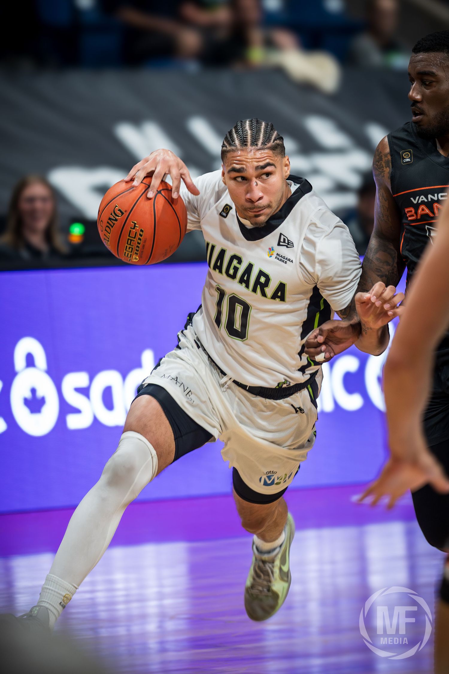 Niagara River Lions player #10 drives to the basket against Vancouver Bandits defender in CEBL action.