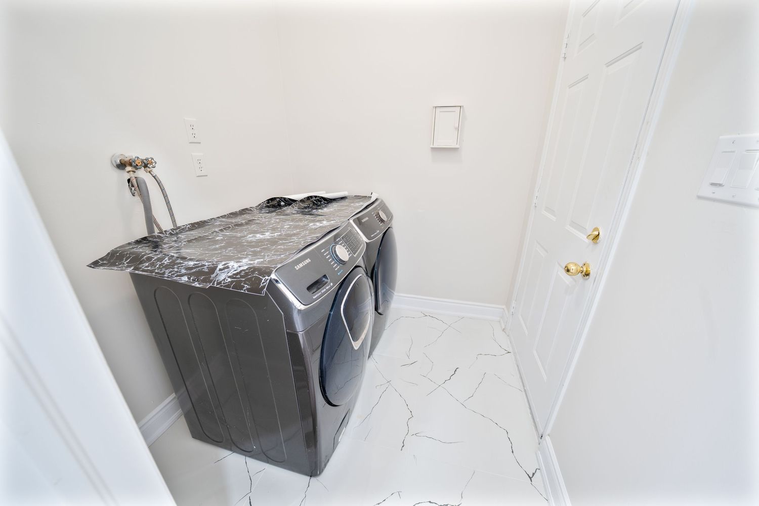 White washing machine and dryer appliances installed side by side in a modern laundry room.