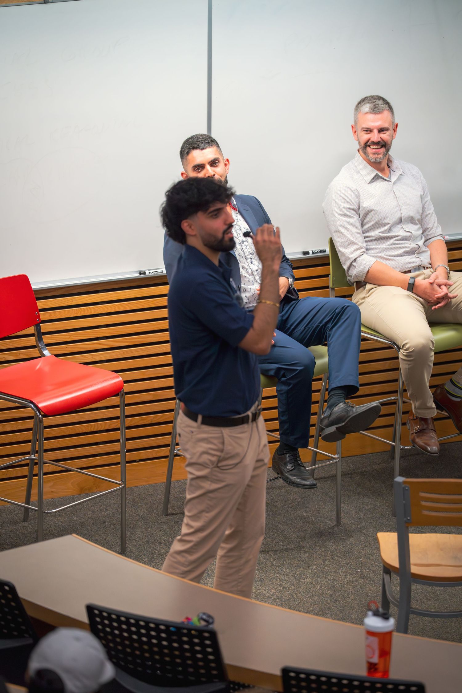 Meeting participants engaged in lively discussion in a modern conference room setting.