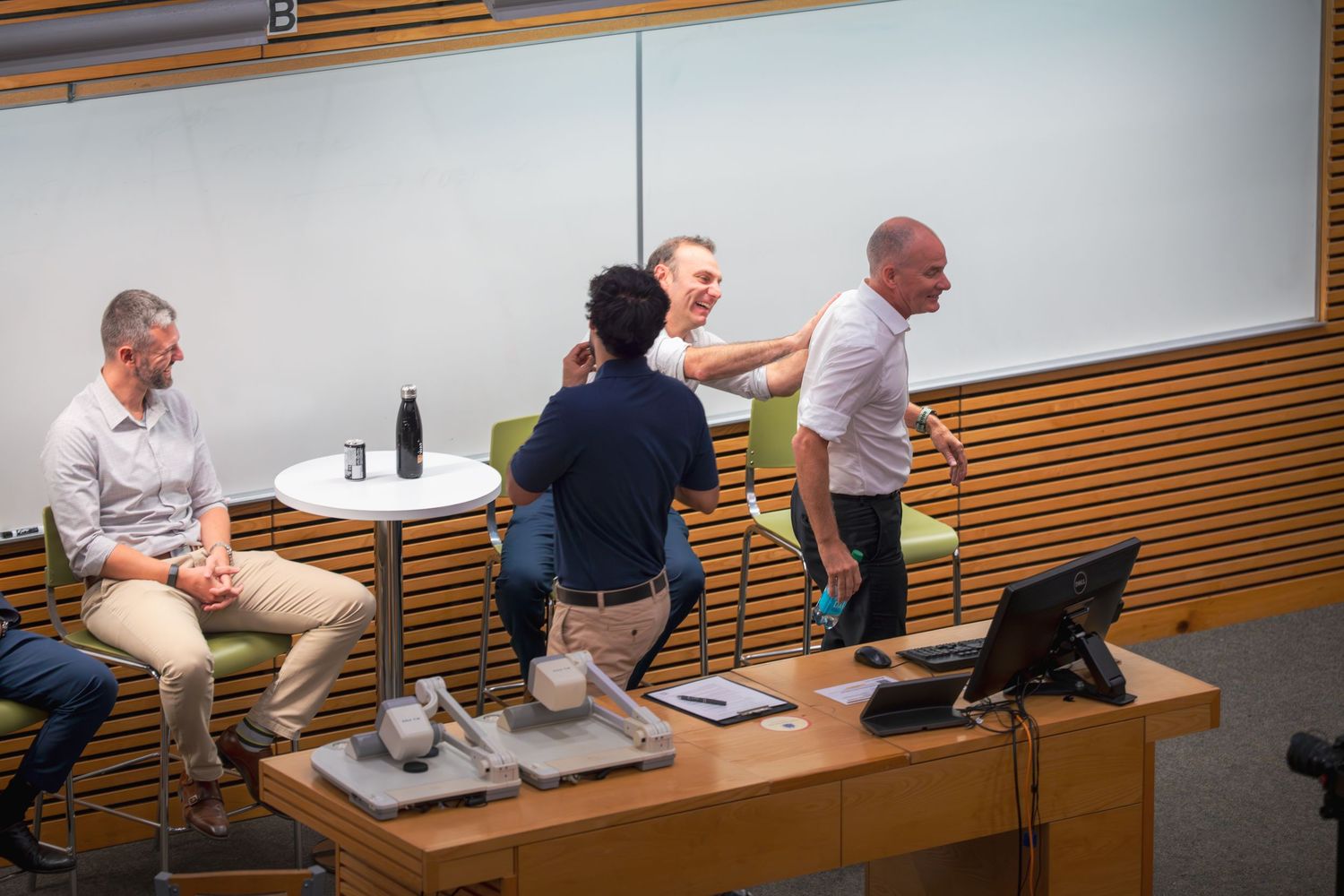 Panel members engaged in discussion at front of lecture hall.
