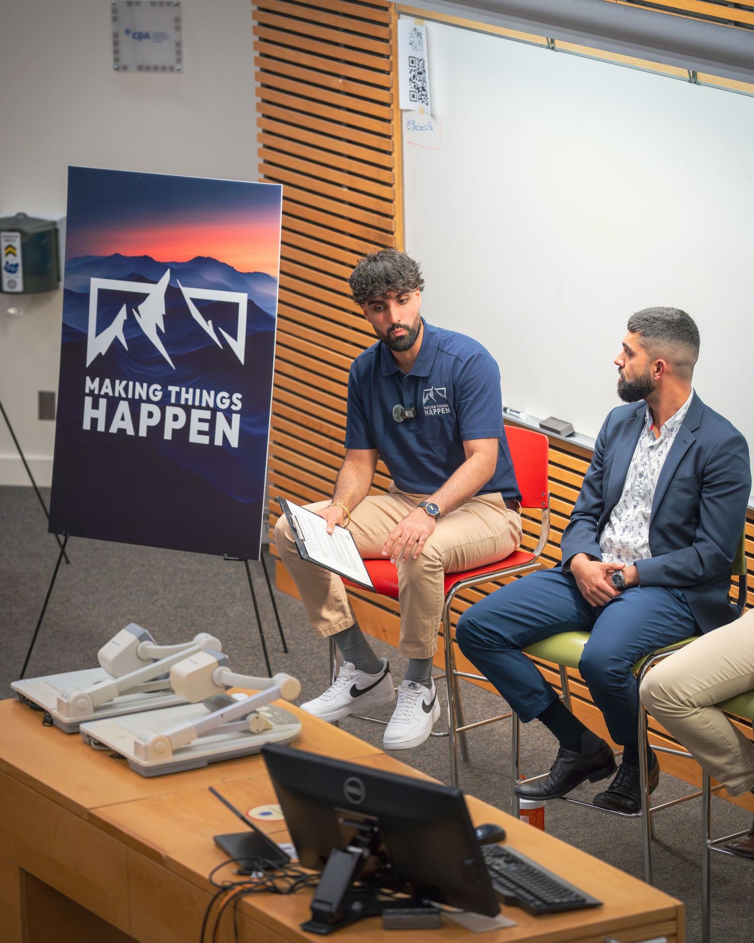 Business meeting in progress with casual seating and branded backdrop.