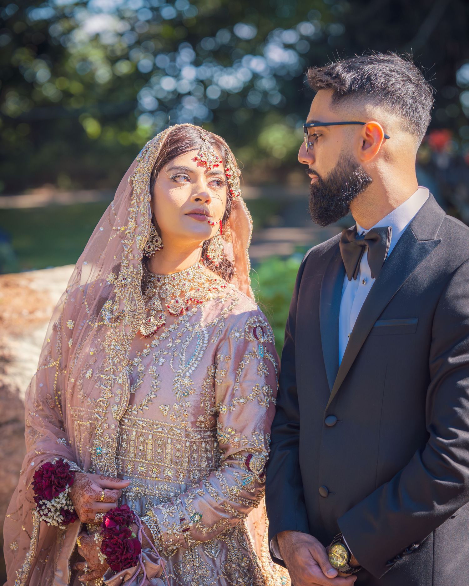 Wedding portraits in a garden setting with couple in traditional South Asian formal wear.