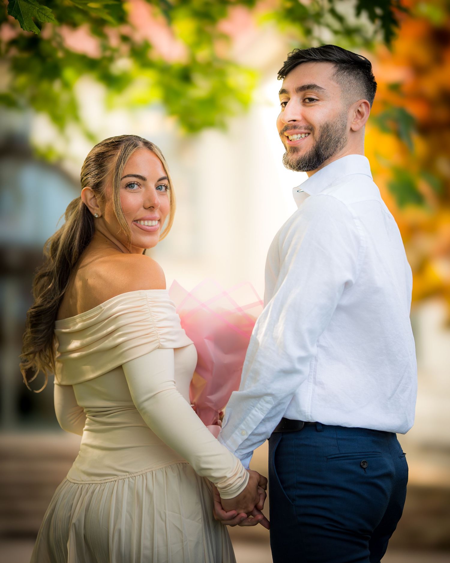 Romantic wedding couple laughing together in a garden setting with soft natural lighting.