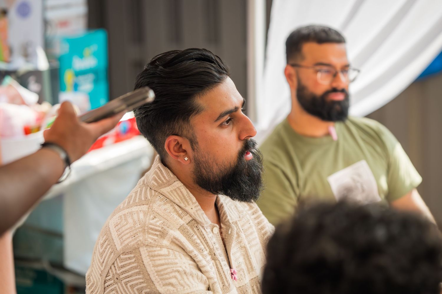 Male guests in casual attire chat during a baby shower celebration.