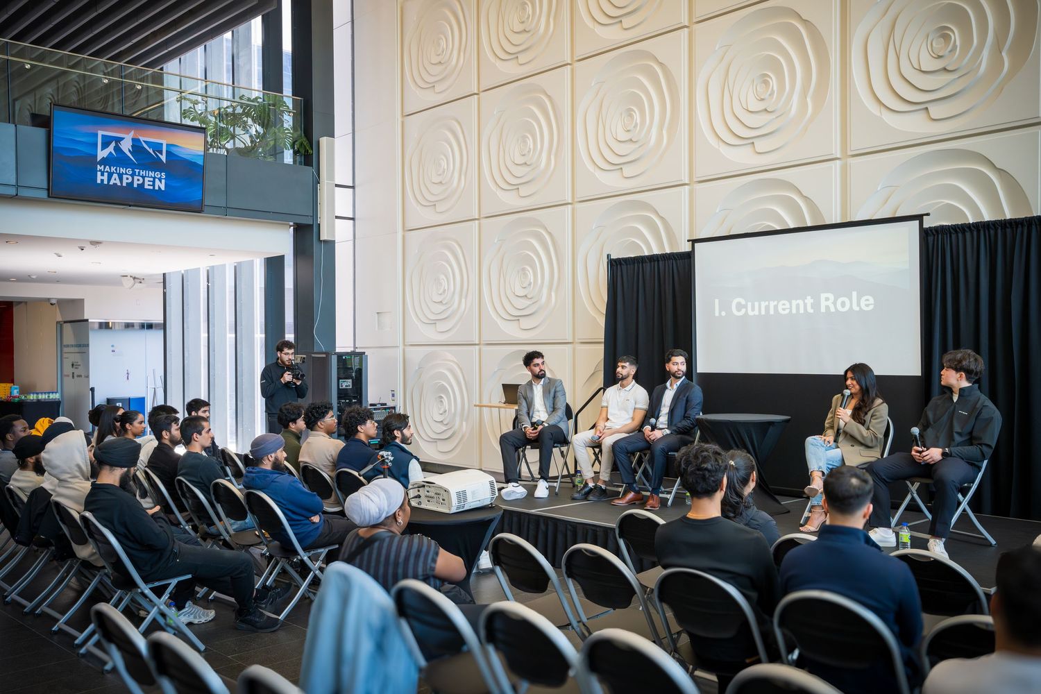 Wide view of conference room with audience attending presentation.