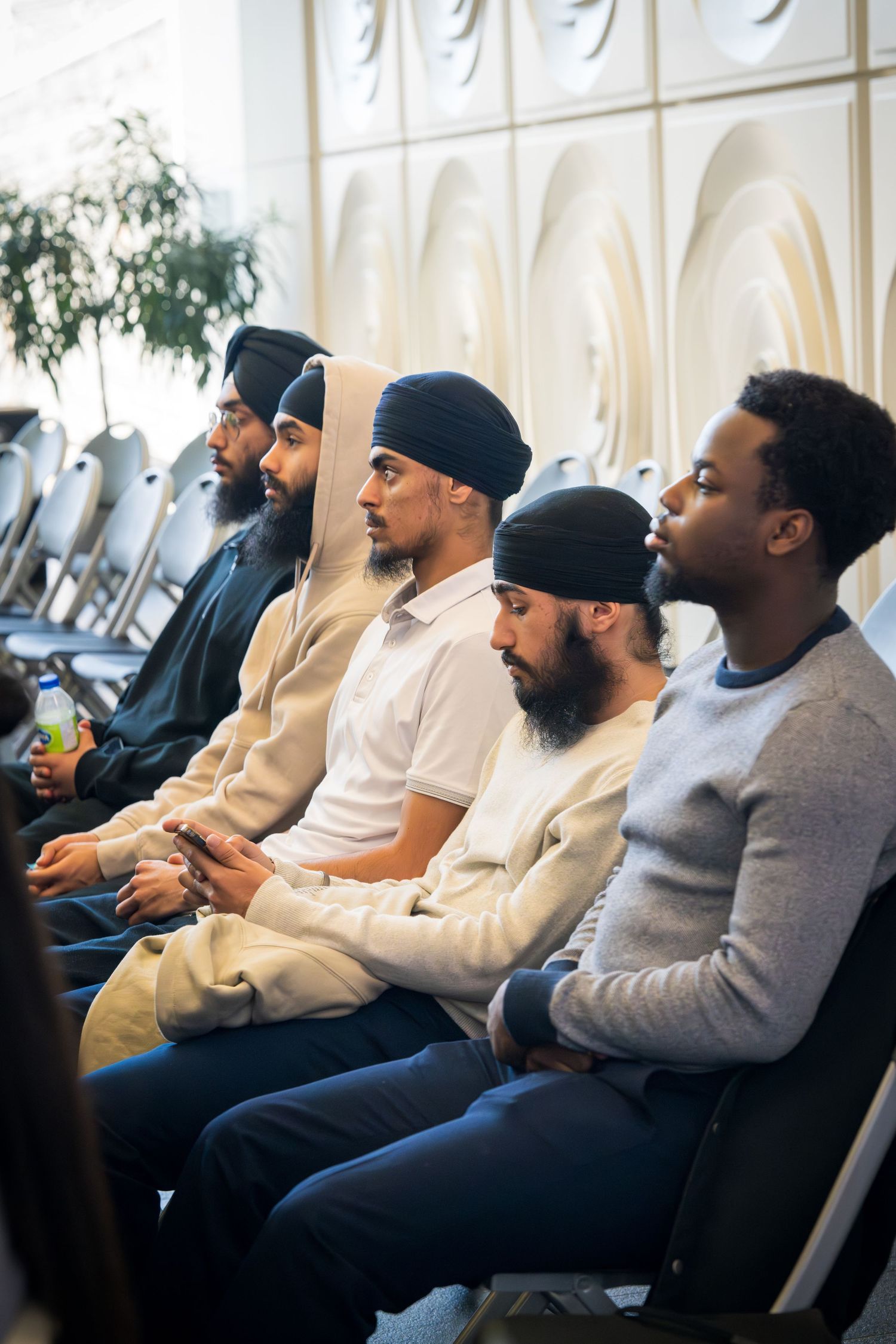 Audience members seated in a row during a professional business conference.