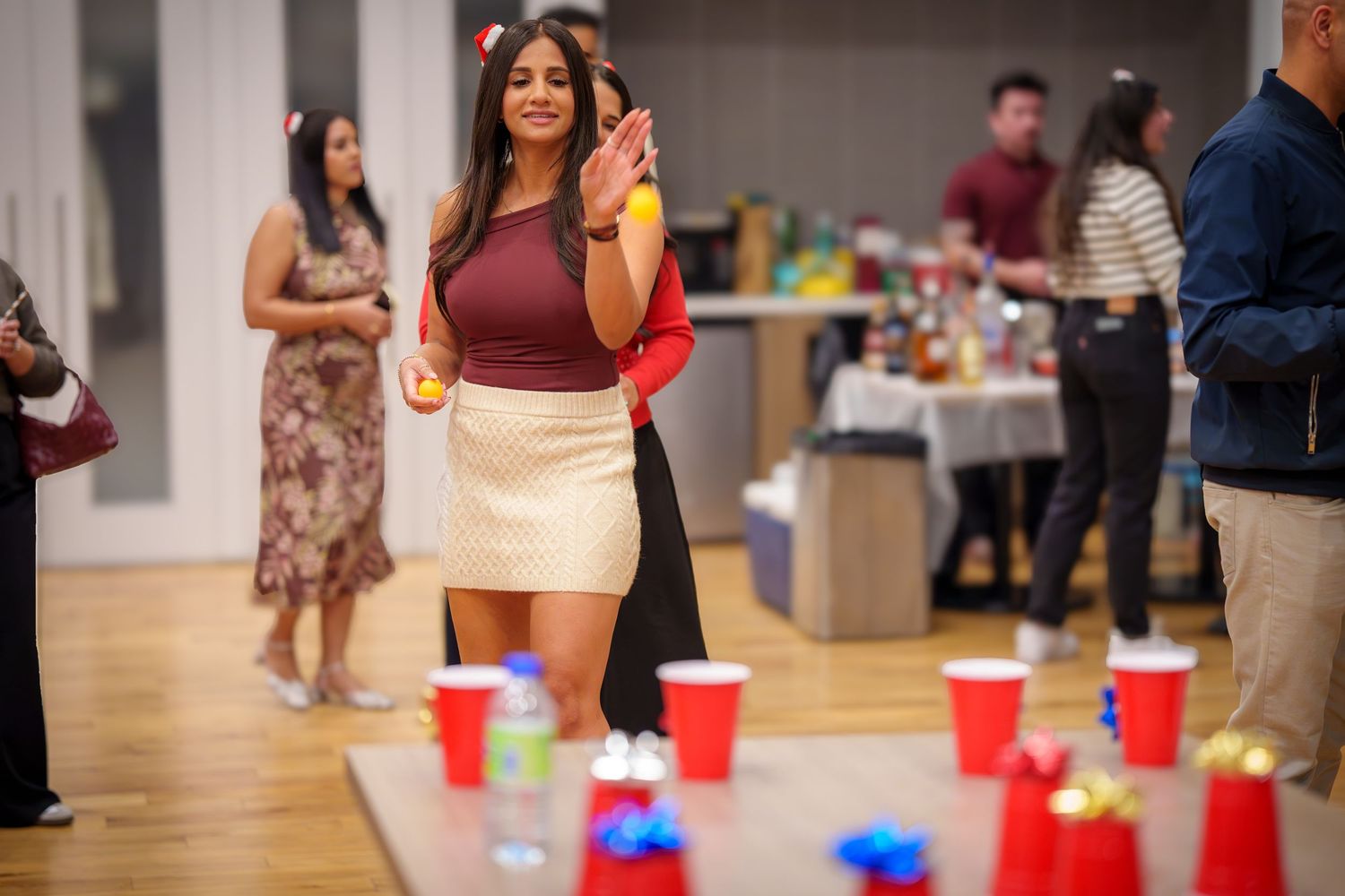 Social gathering with red cups arranged on tables and people mingling in background.