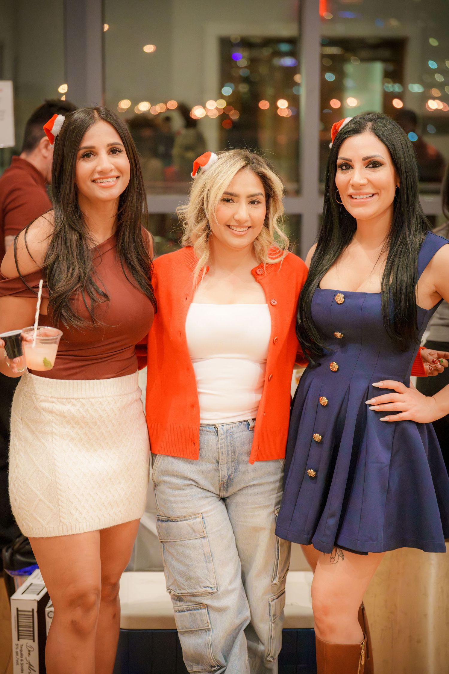 A group of friends pose together wearing colorful outfits at a social gathering.