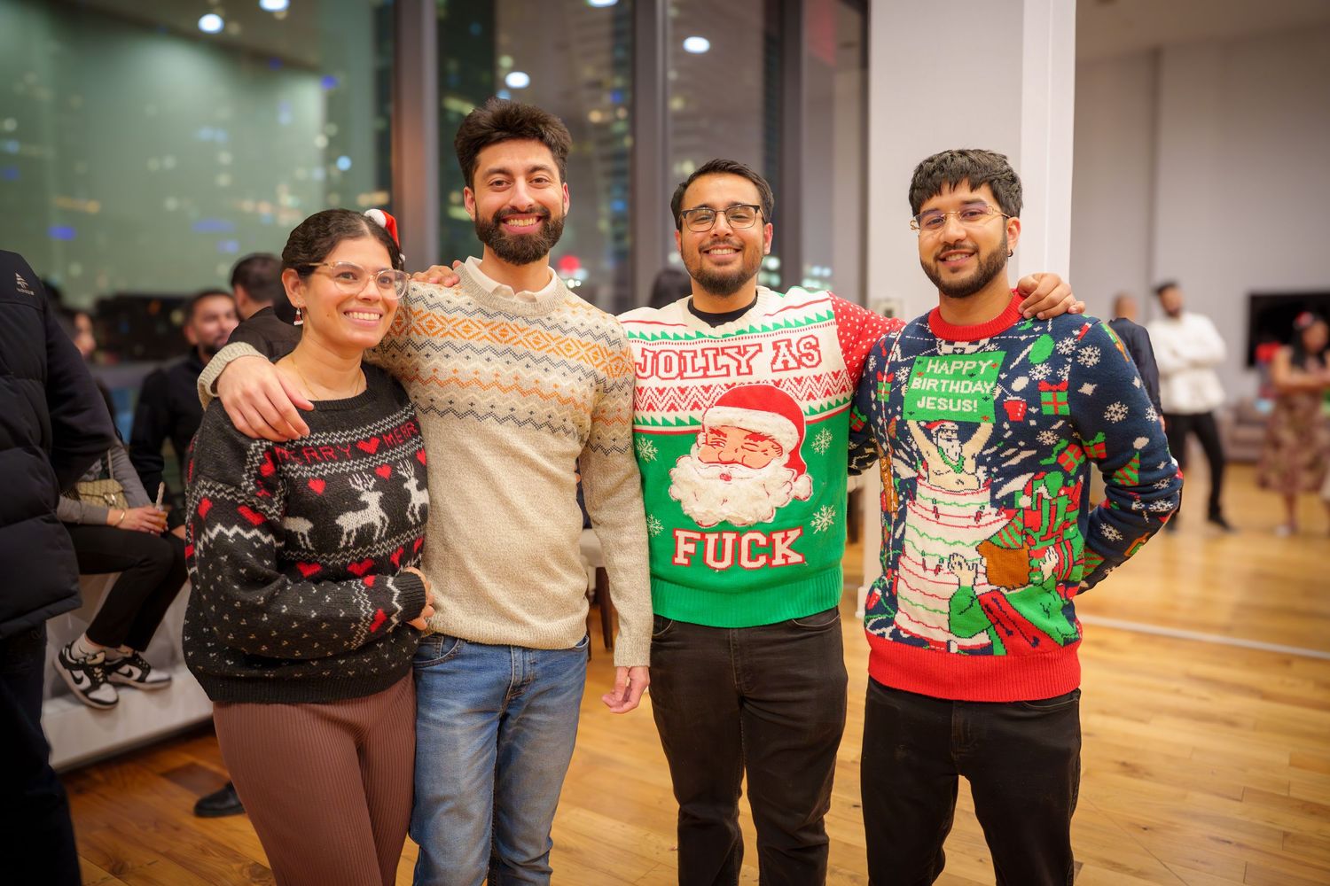 Friends showing off their festive ugly Christmas sweaters at a holiday party.