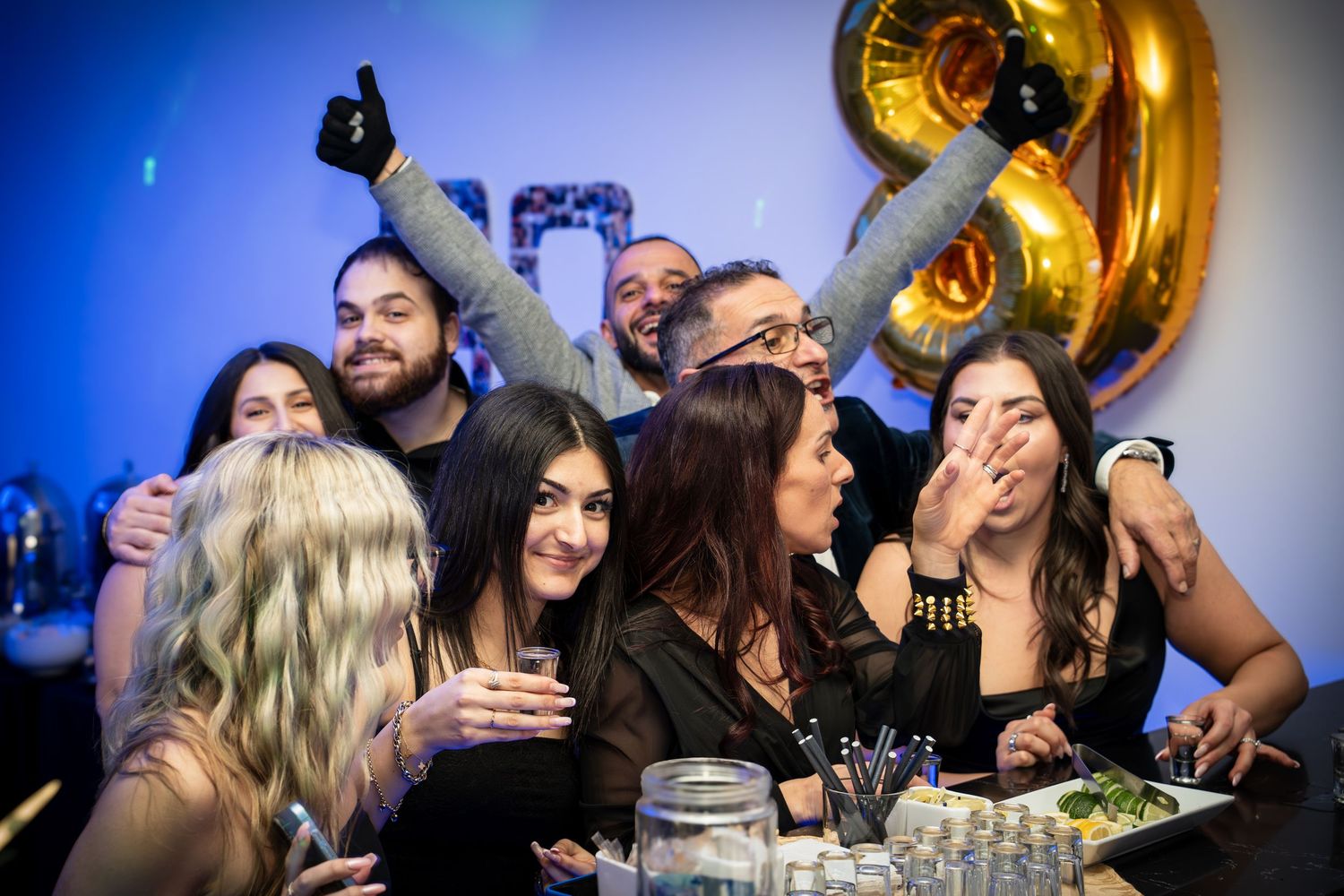 Partygoers celebrating and posing energetically for a photo at a festive gathering.