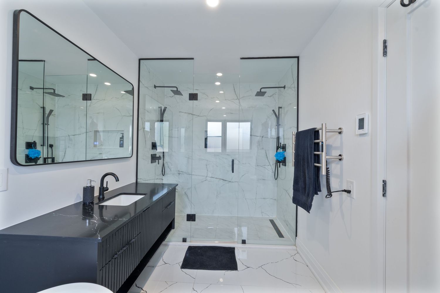 Modern white bathroom interior with glass shower enclosure, floating vanity, and sleek fixtures.