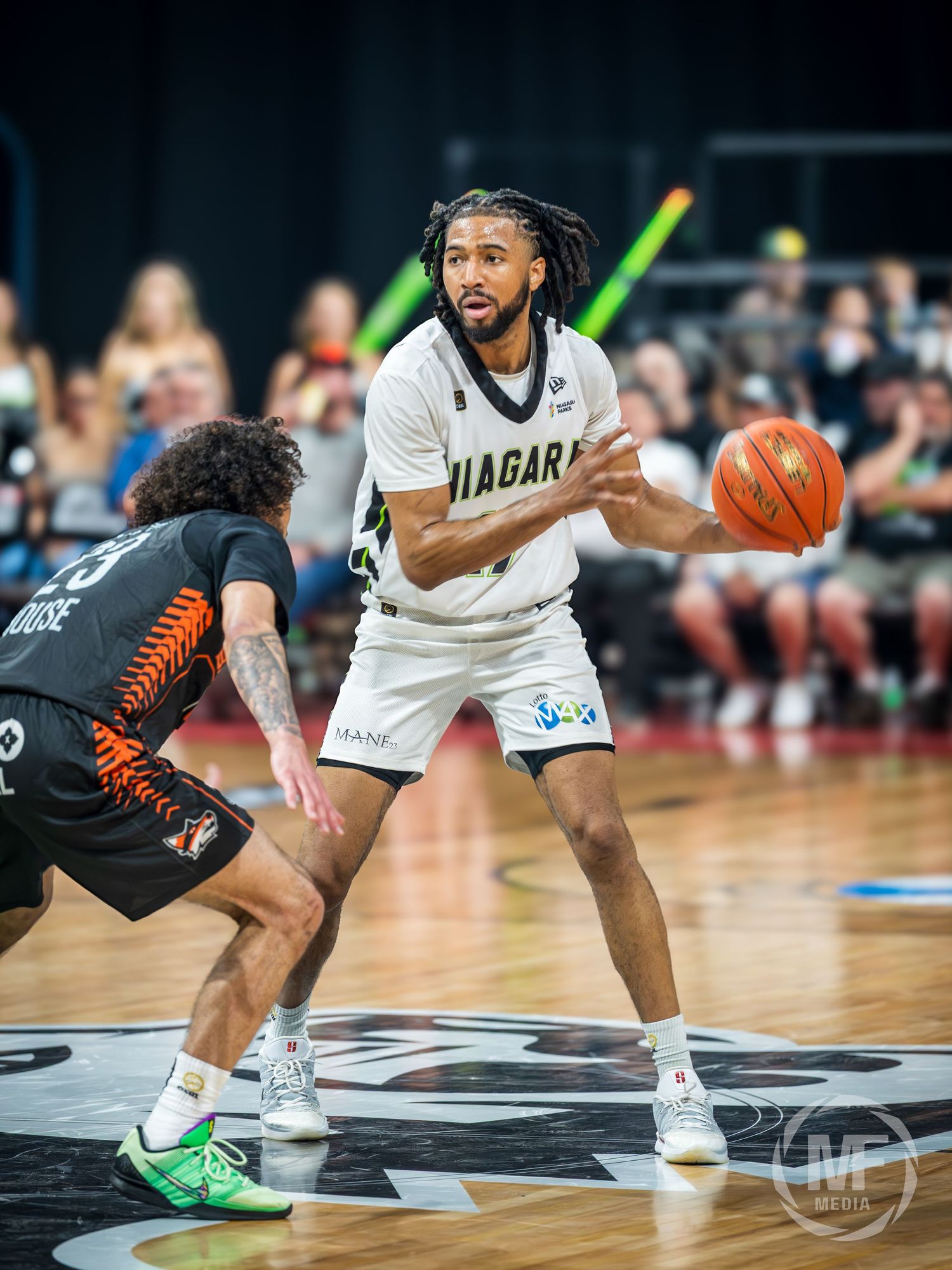 Niagara player number 4 dribbles against defender in white uniform during basketball game.