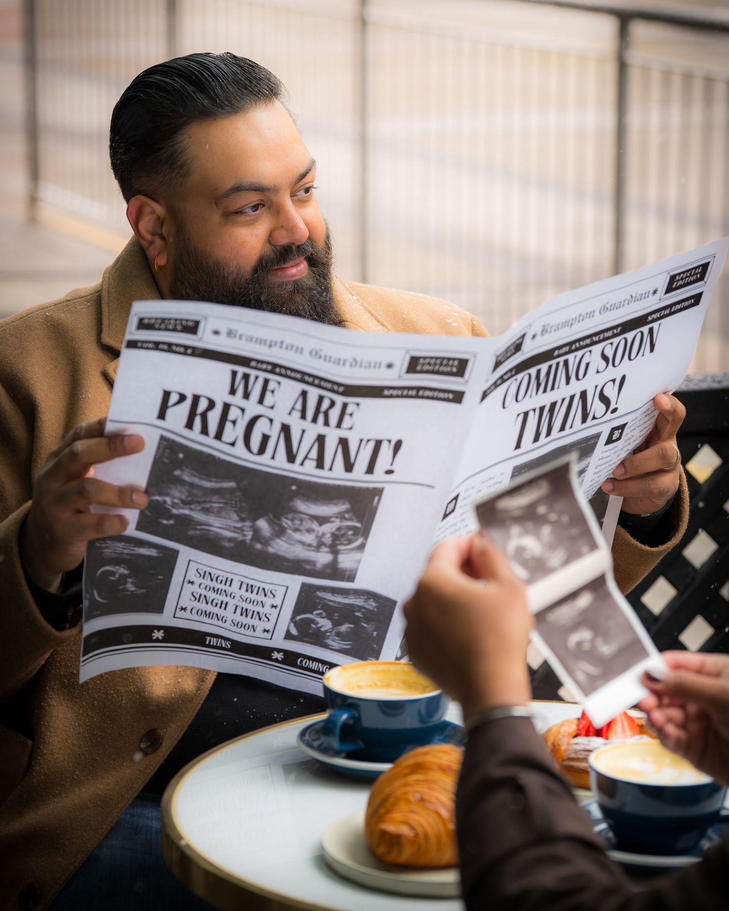 Creative pregnancy announcement series showing couple reading newspaper headlines at outdoor cafe.