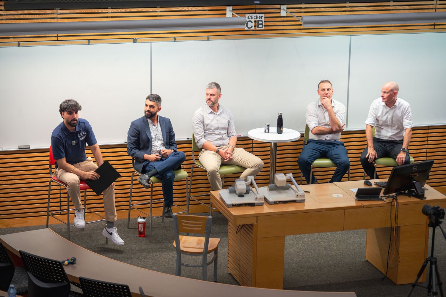 Wide view of a modern conference room with multiple attendees seated around tables.