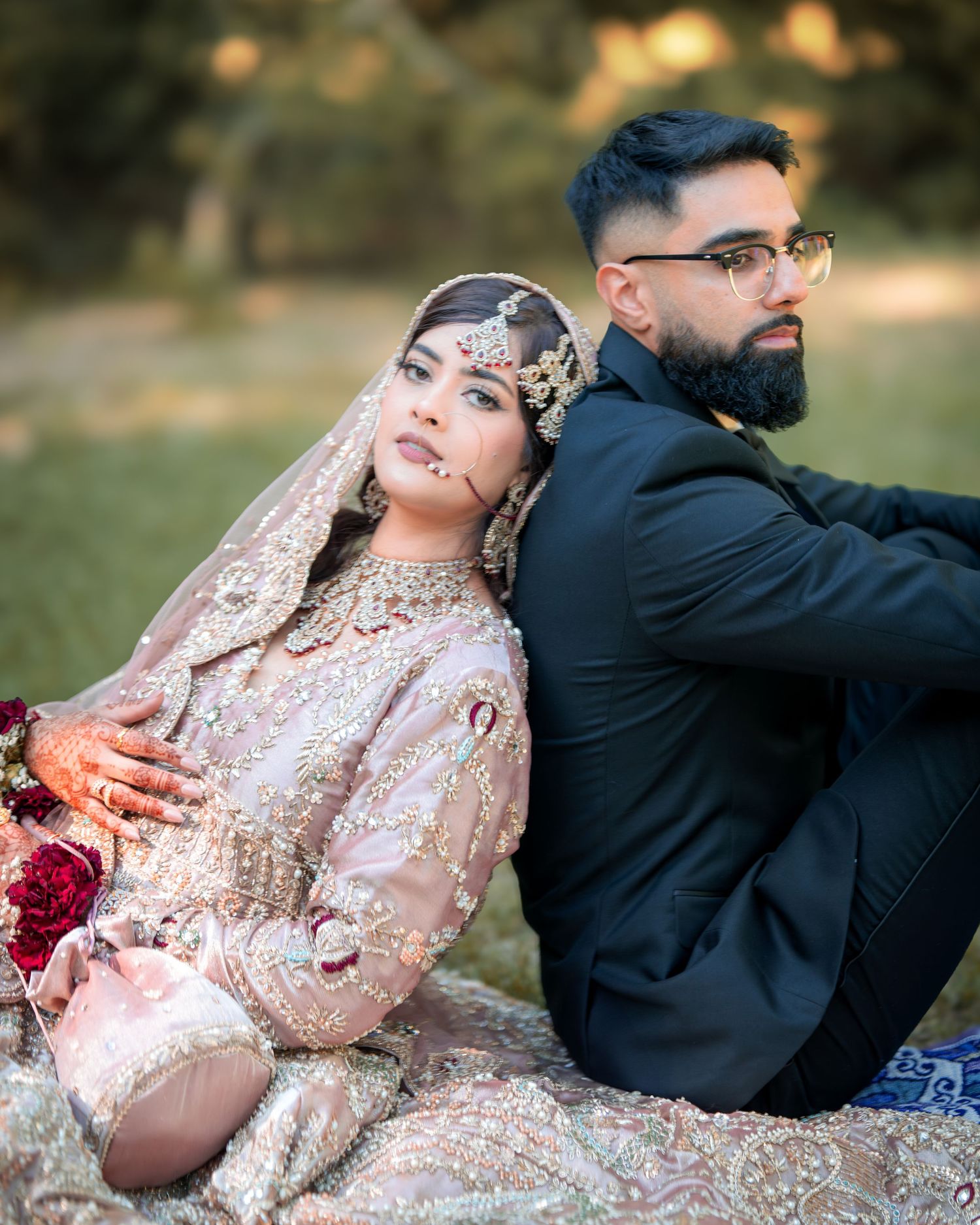 Wedding couple in traditional South Asian dress share candid moments during outdoor photography session.