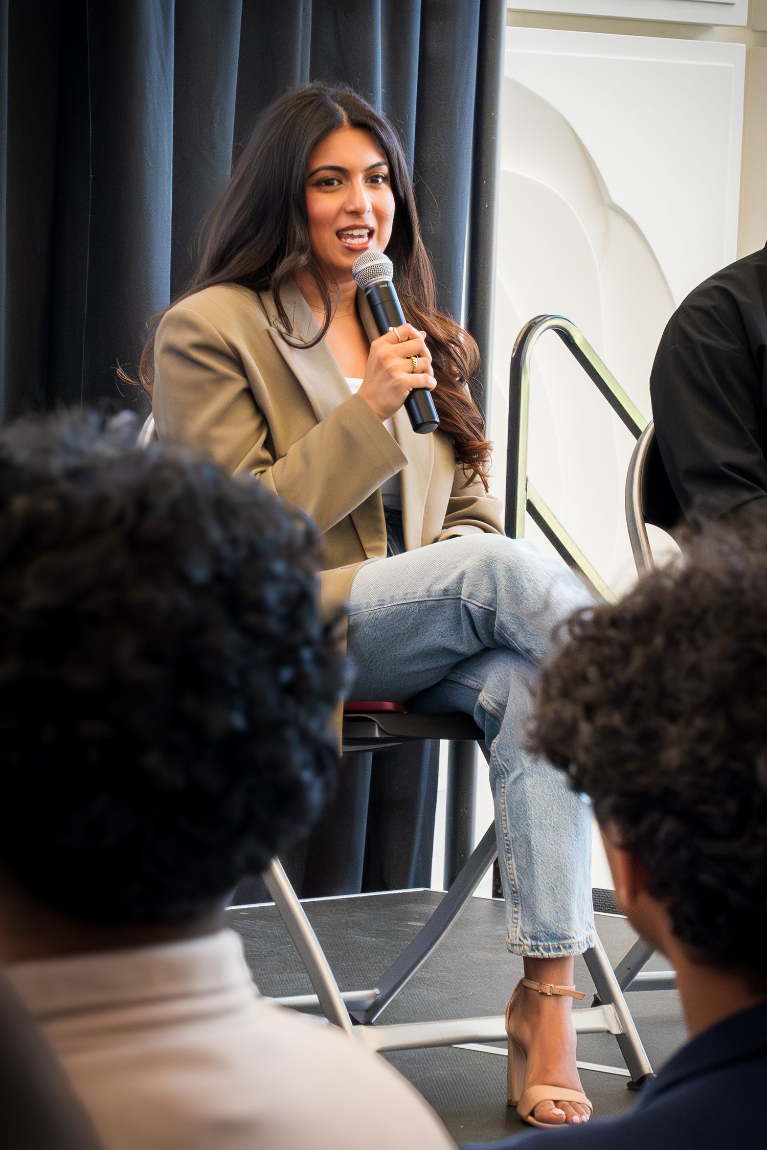 Speaker engaging with audience during professional panel discussion in modern venue.