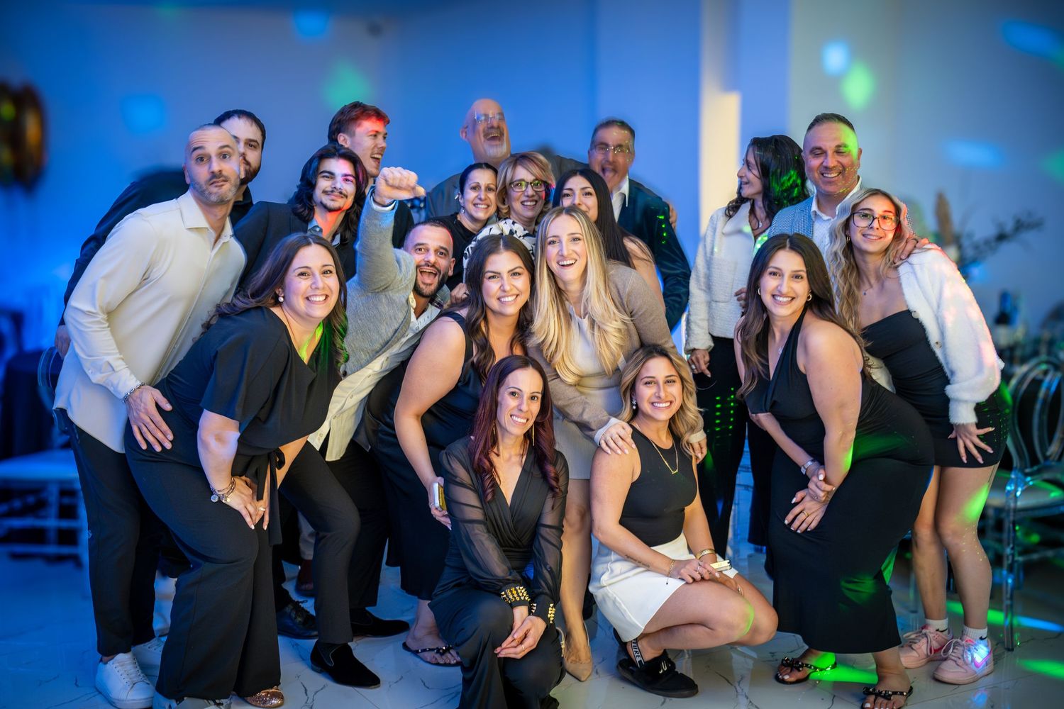 Lively dance party scene with guests enjoying themselves under colorful venue lighting.