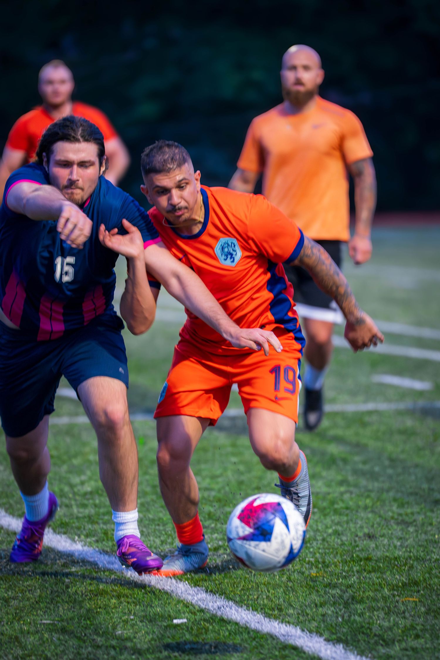 Soccer players battle for ball control during intense match on grass field.
