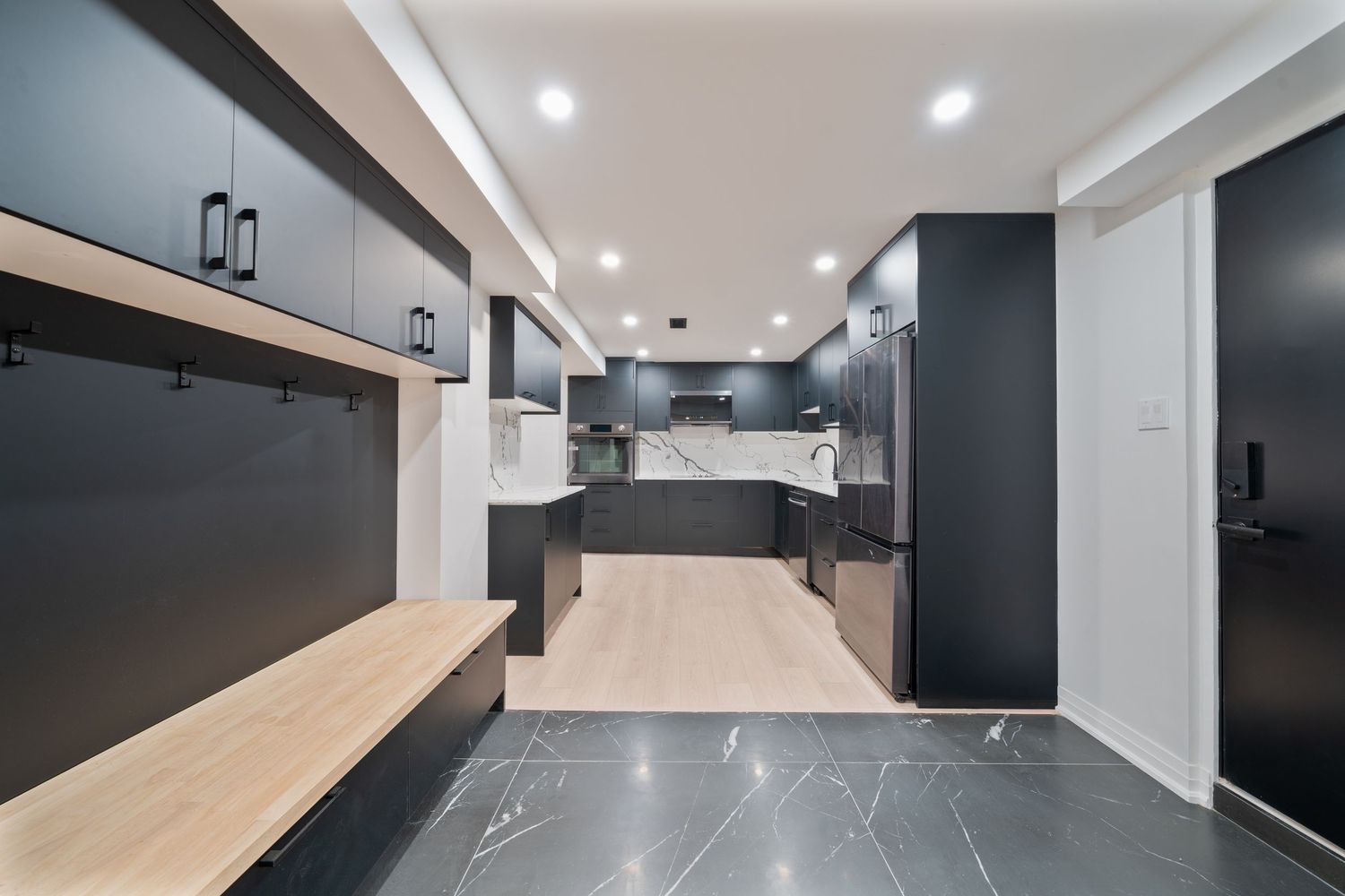 Modern office interior with light wood floors and black accent walls features sleek minimalist design and recessed lighting.