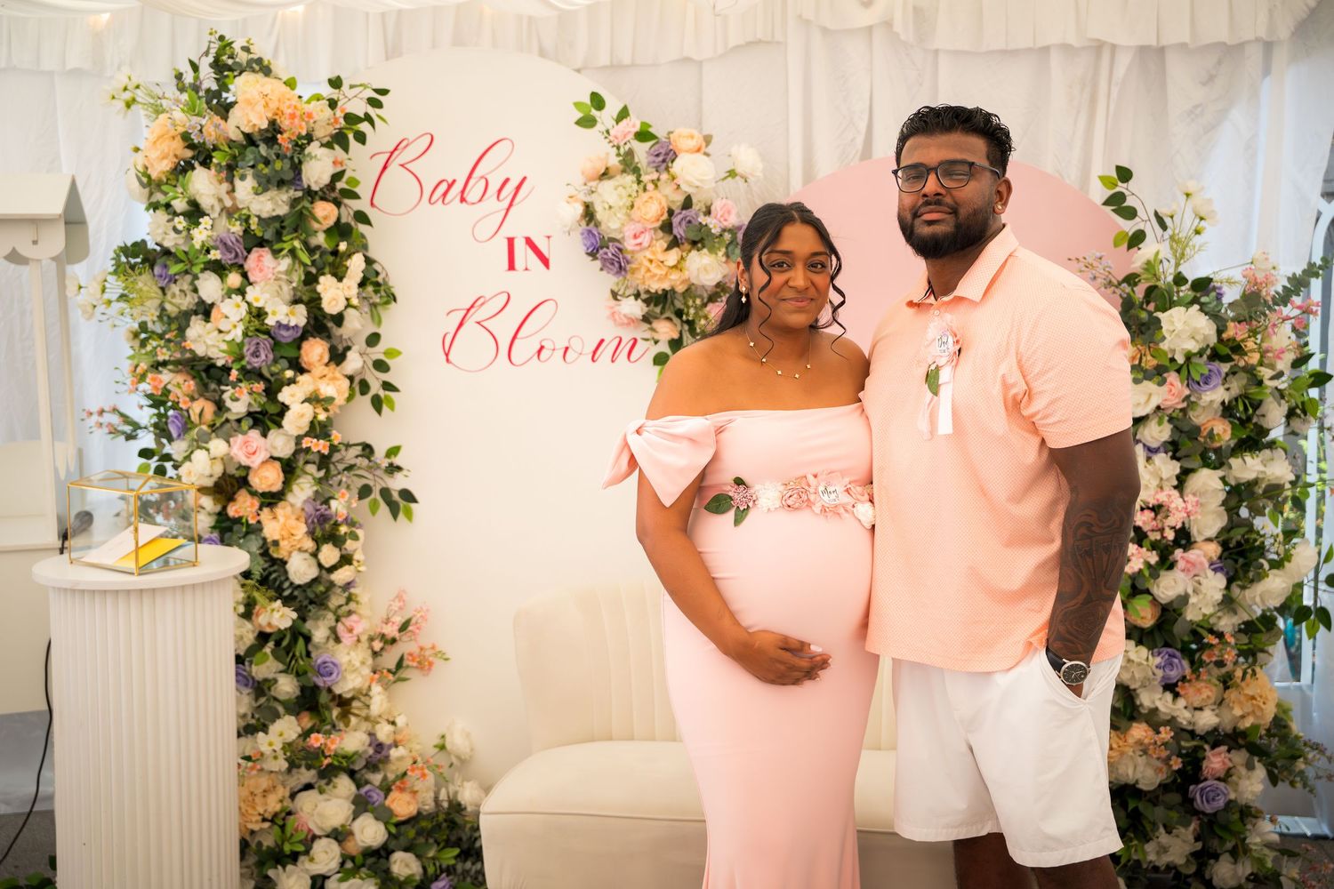 Celebration space decorated with peach and white floral arrangements and elegant draping.