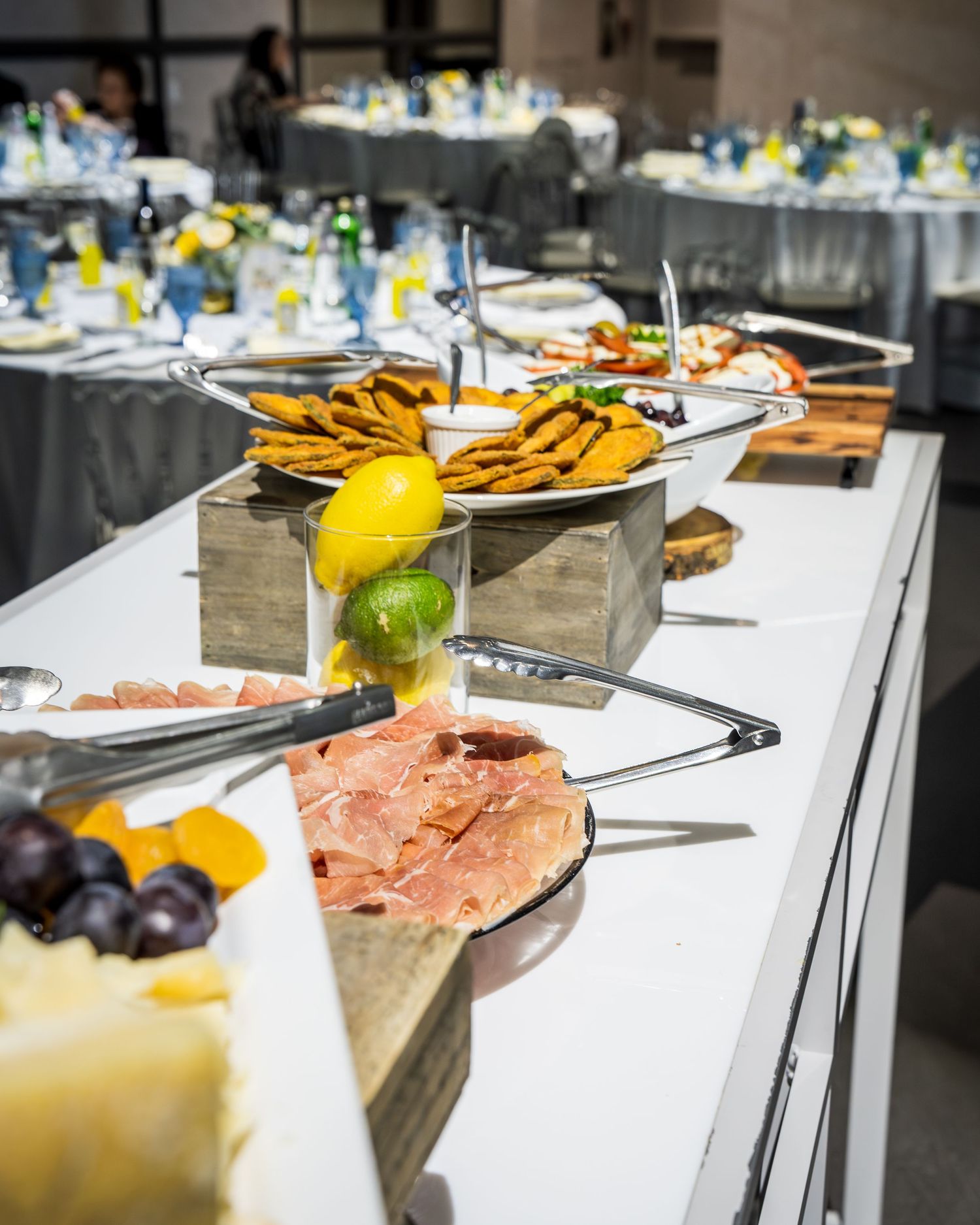 Elegant wedding reception buffet table with charcuterie, crackers, and fresh fruit displays.