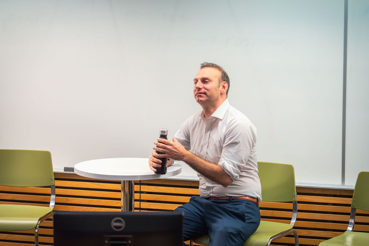 Speaker engages with audience during a presentation in a classroom setting.