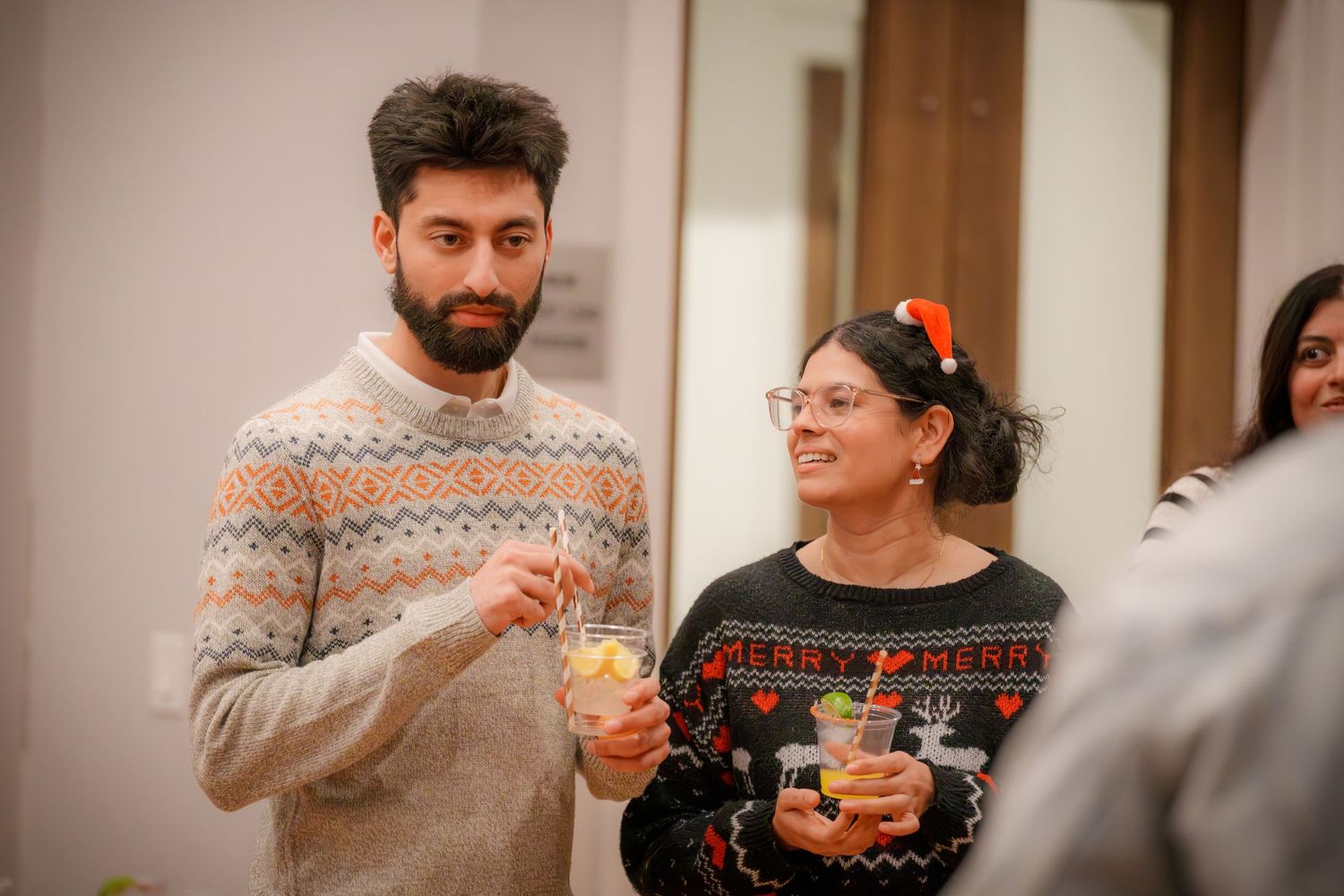Group enjoying a casual indoor gathering wearing winter sweaters.
