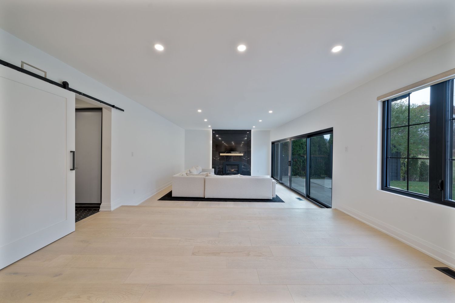 Modern white kitchen with sleek cabinets, recessed lighting, and a large center island features clean minimalist design.