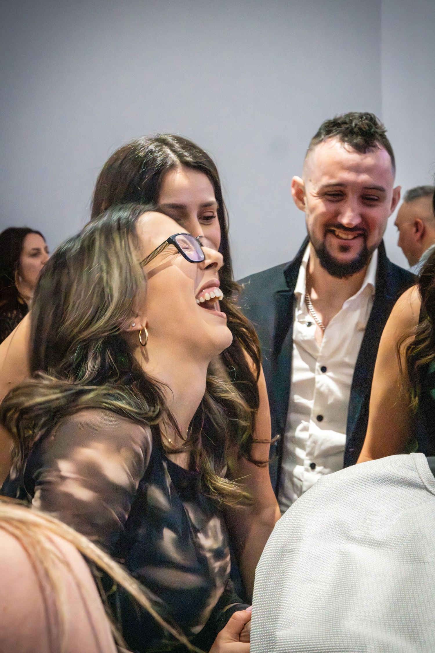 A candid moment of laughter and joy at an elegant social gathering.
