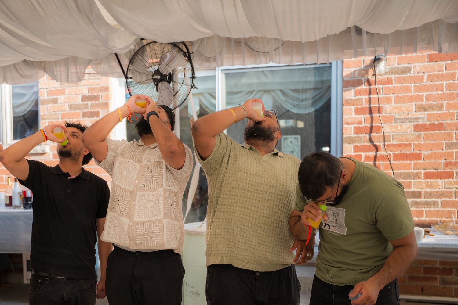 Multiple people drinking beverages simultaneously at a party.