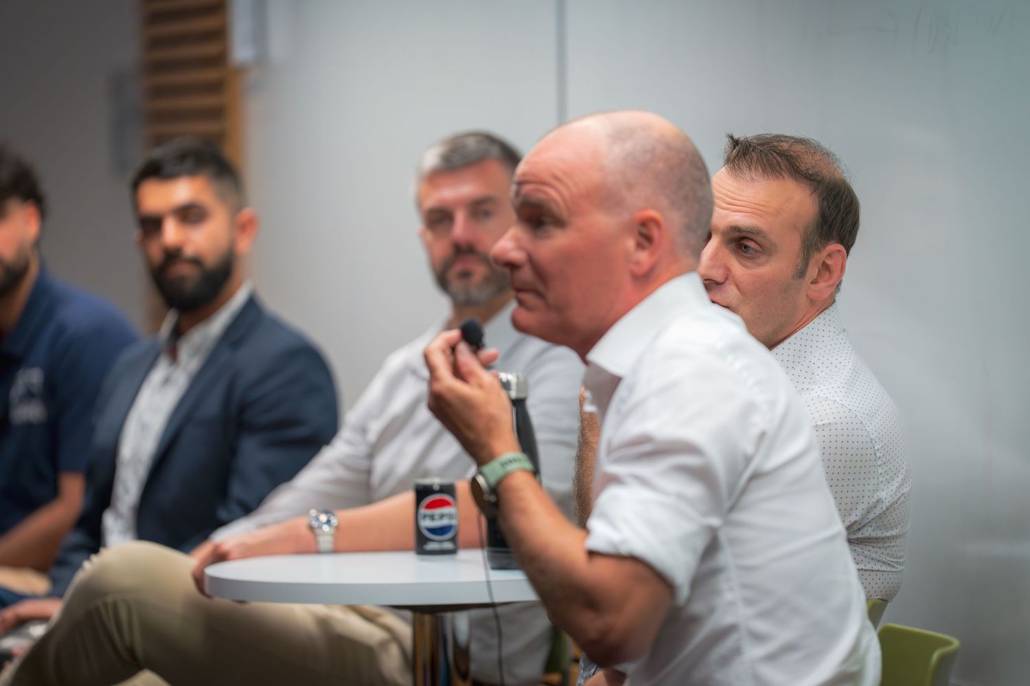 Attendees participating in an informal discussion session in a corporate setting.