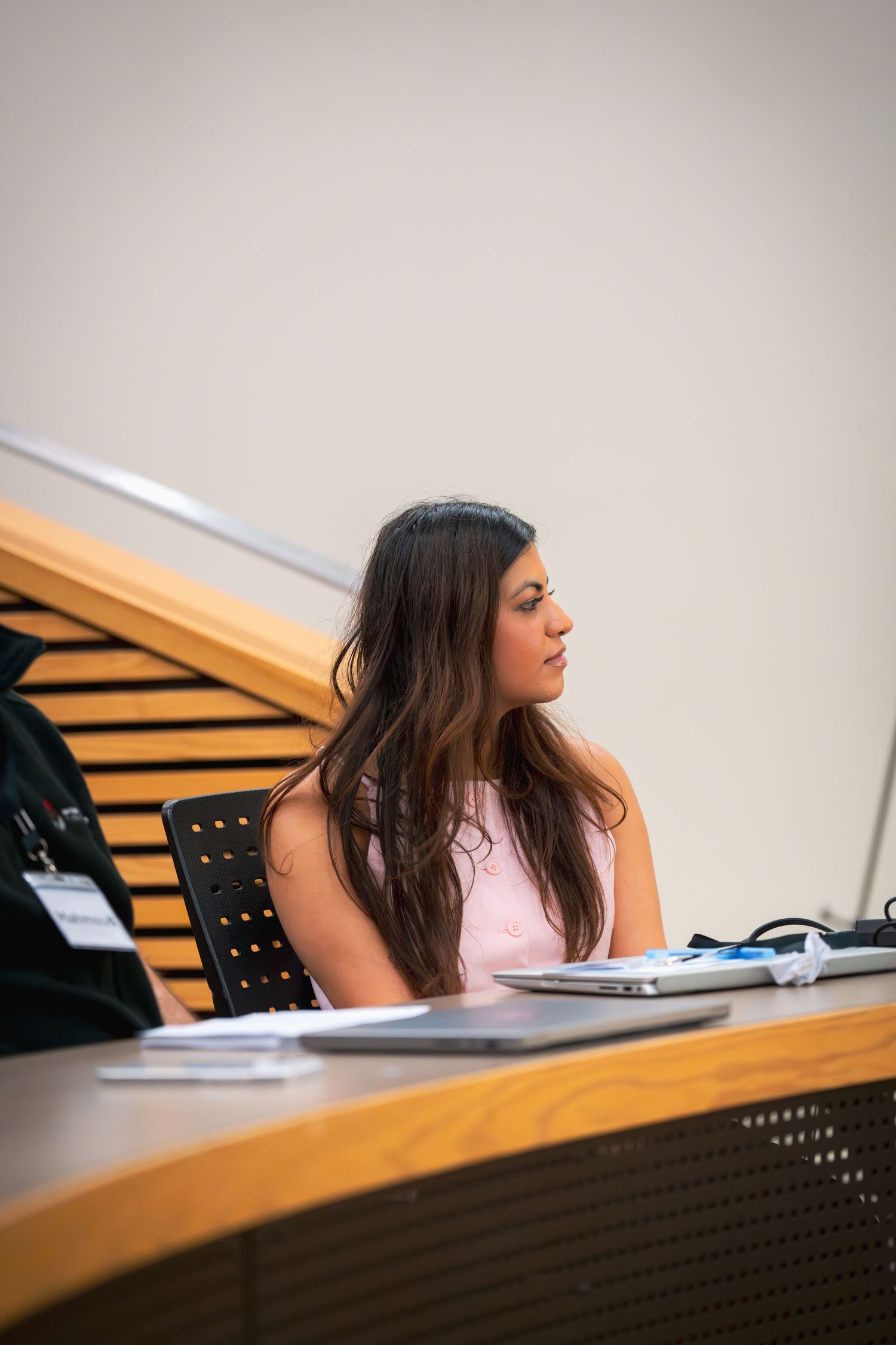 Student focusing intently during a lecture in a modern classroom setting.