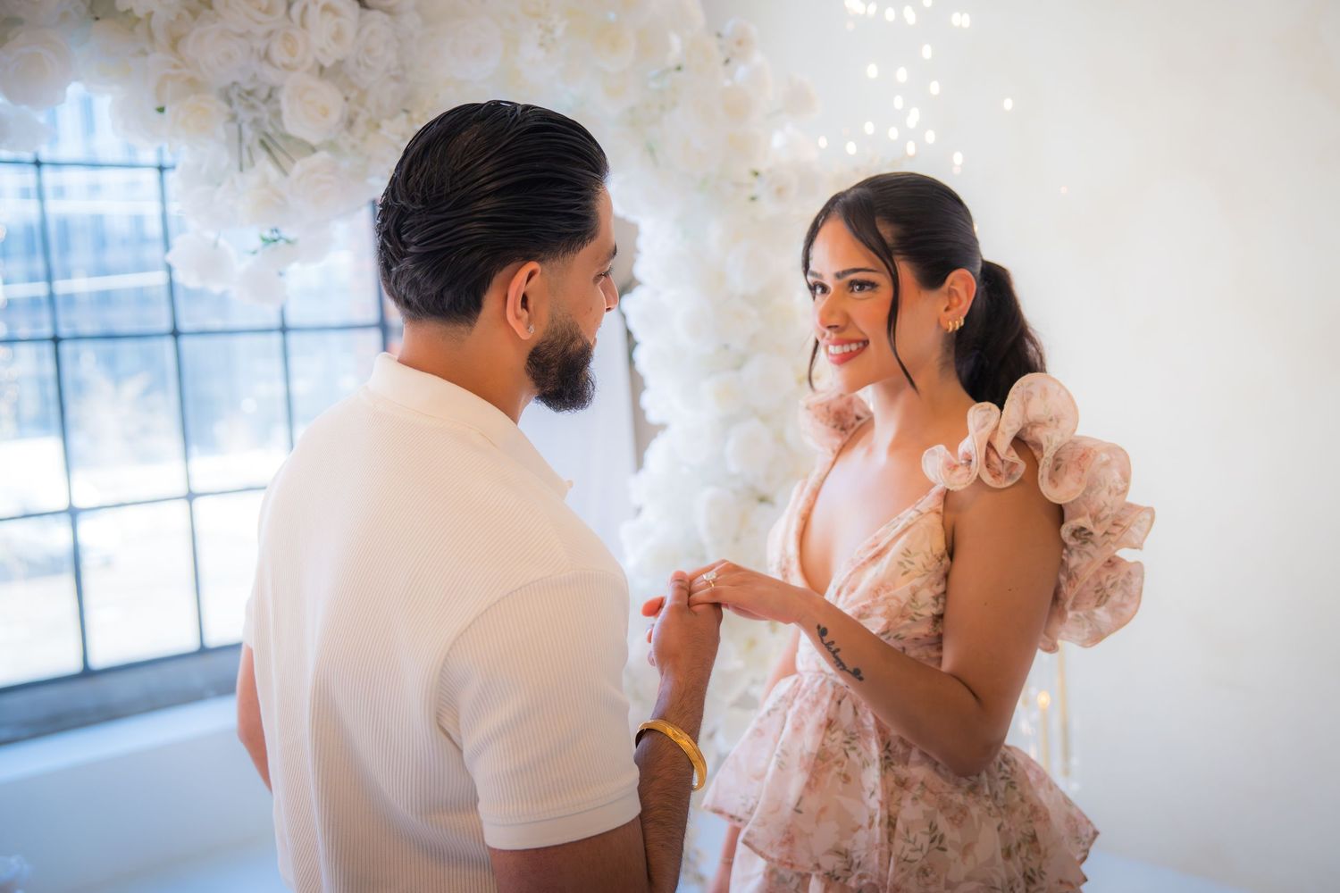 Couple sharing a joyful moment as man places engagement ring on womans finger.
