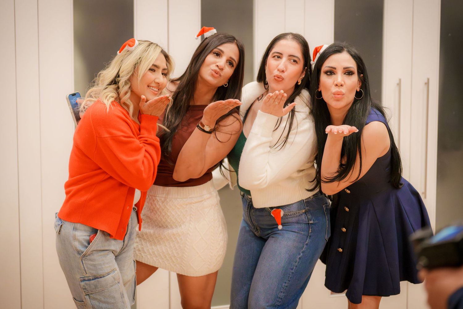 Group of friends in casual attire posing playfully for a photo at a party.