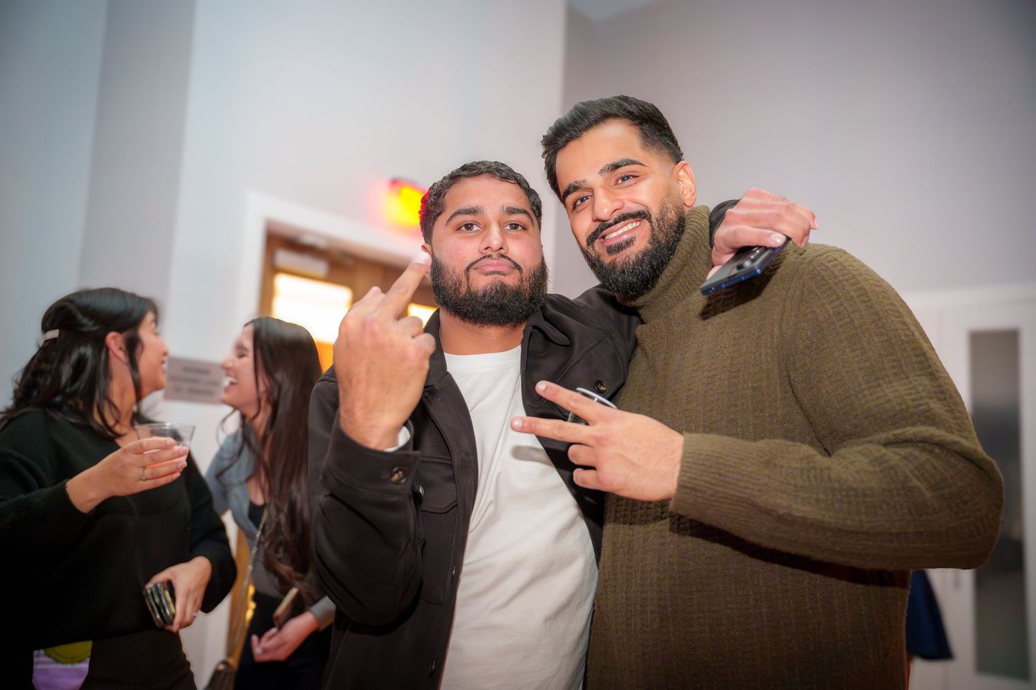 Group of friends having fun and taking photos at a social gathering.
