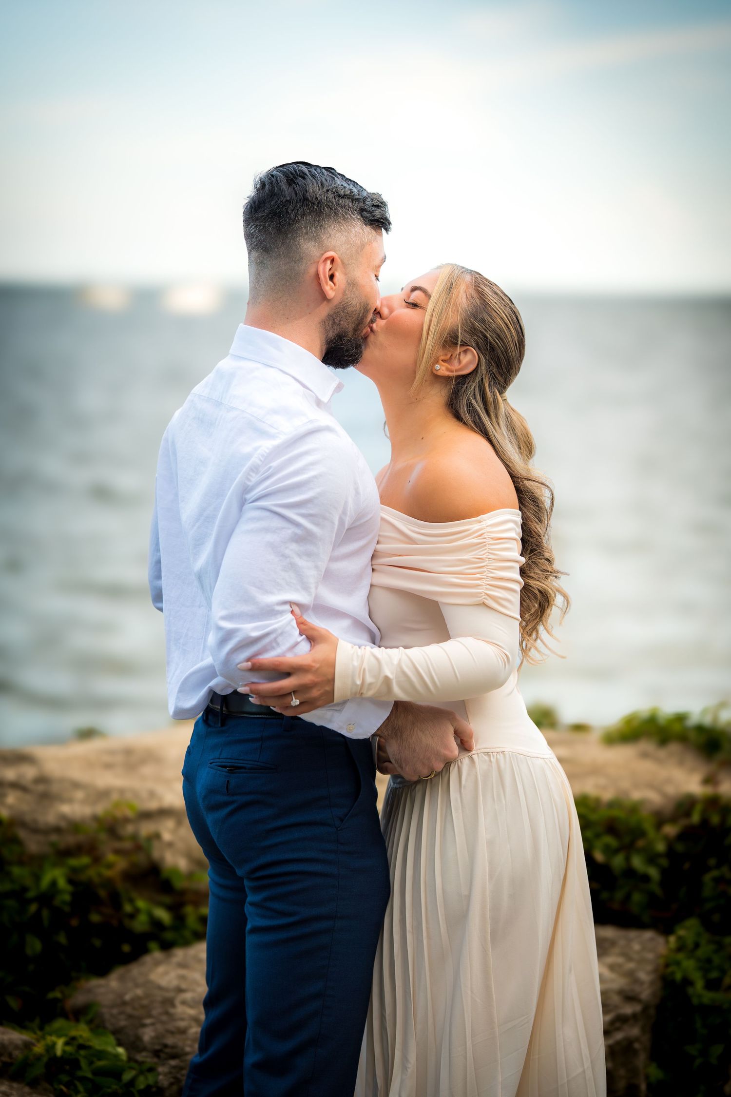 A couple shares an intimate moment by the ocean during a photo session.
