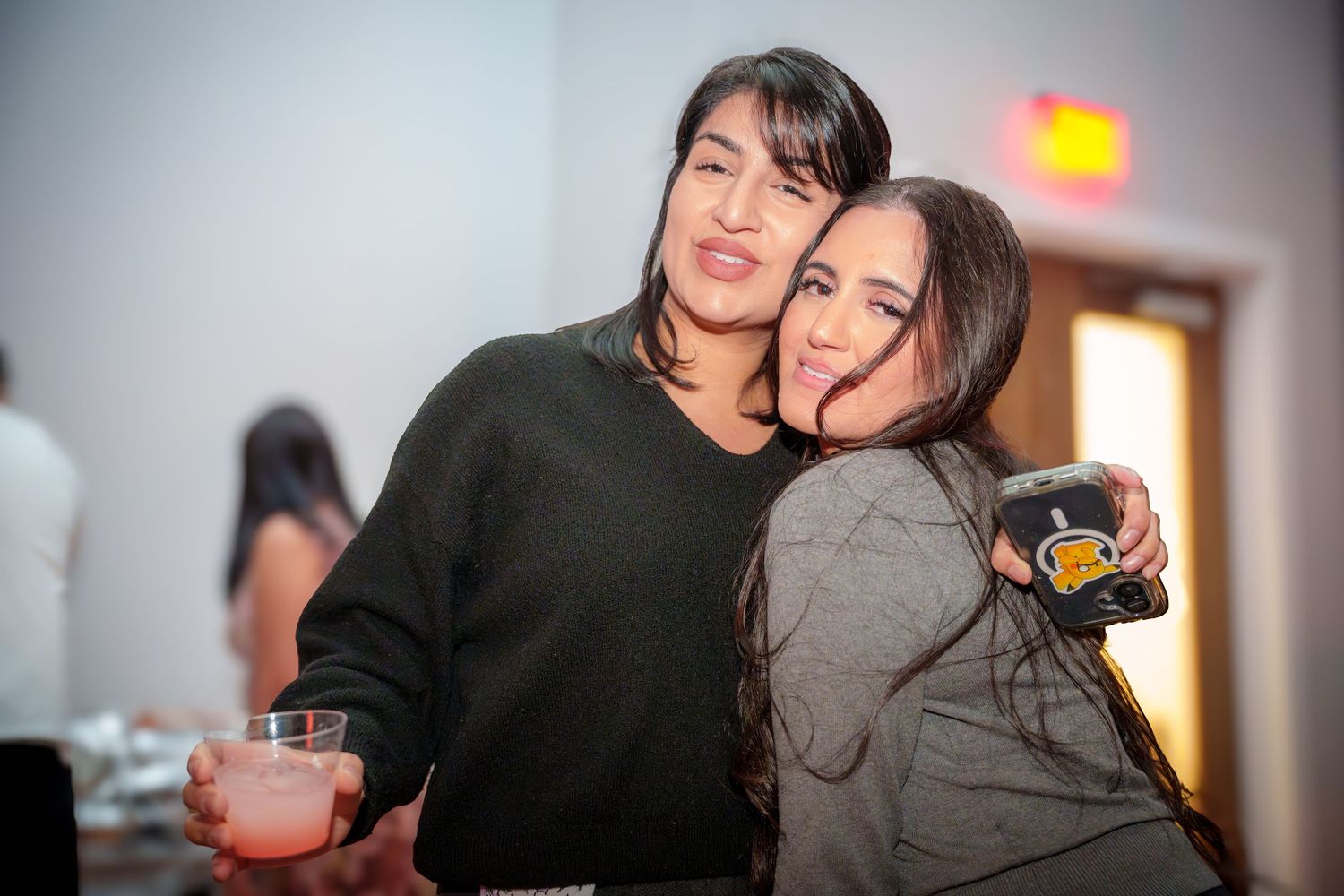 Friends sharing intimate moments during indoor party celebration.