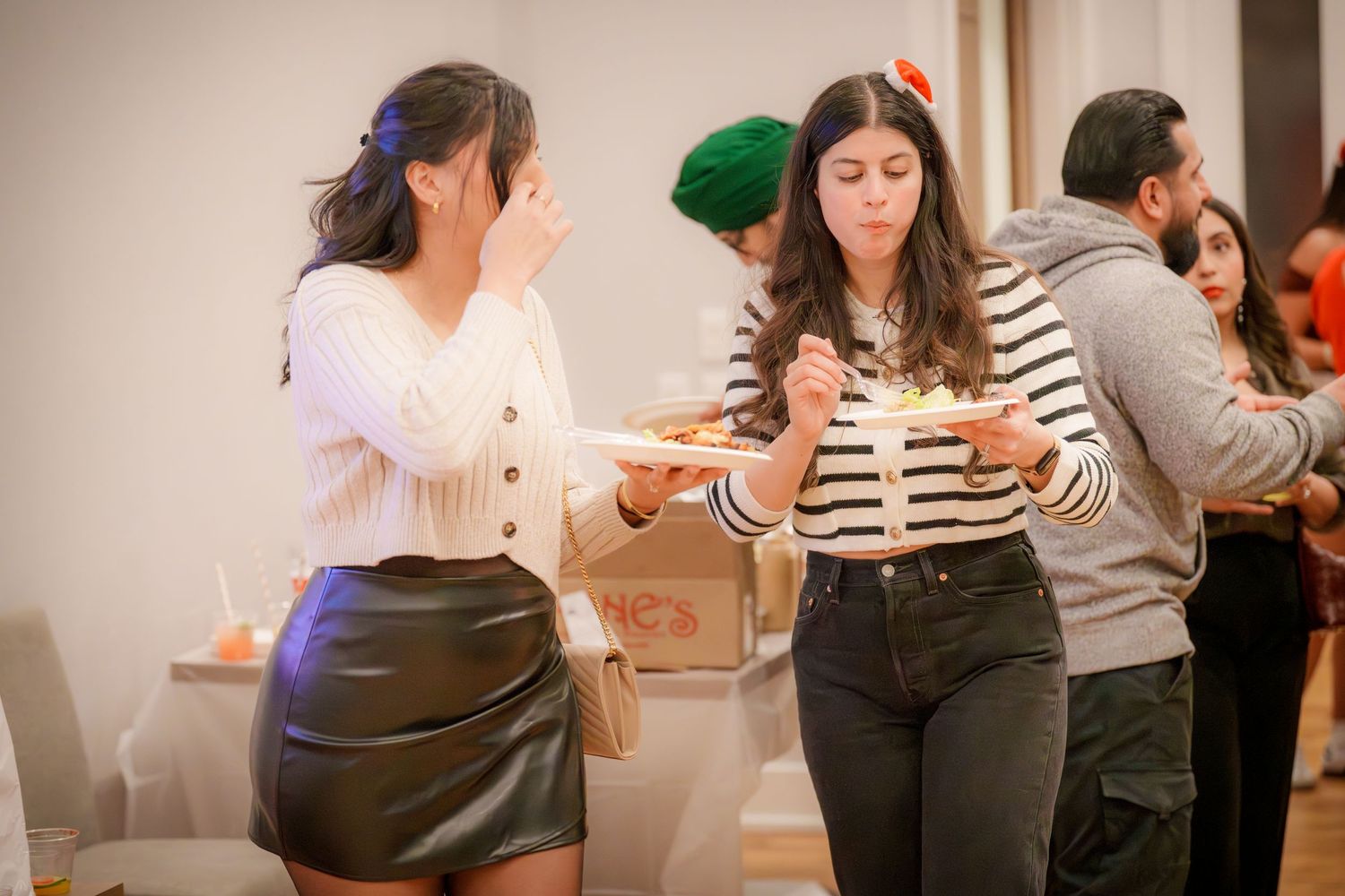 Group of people socializing at an indoor gathering with casual dress.