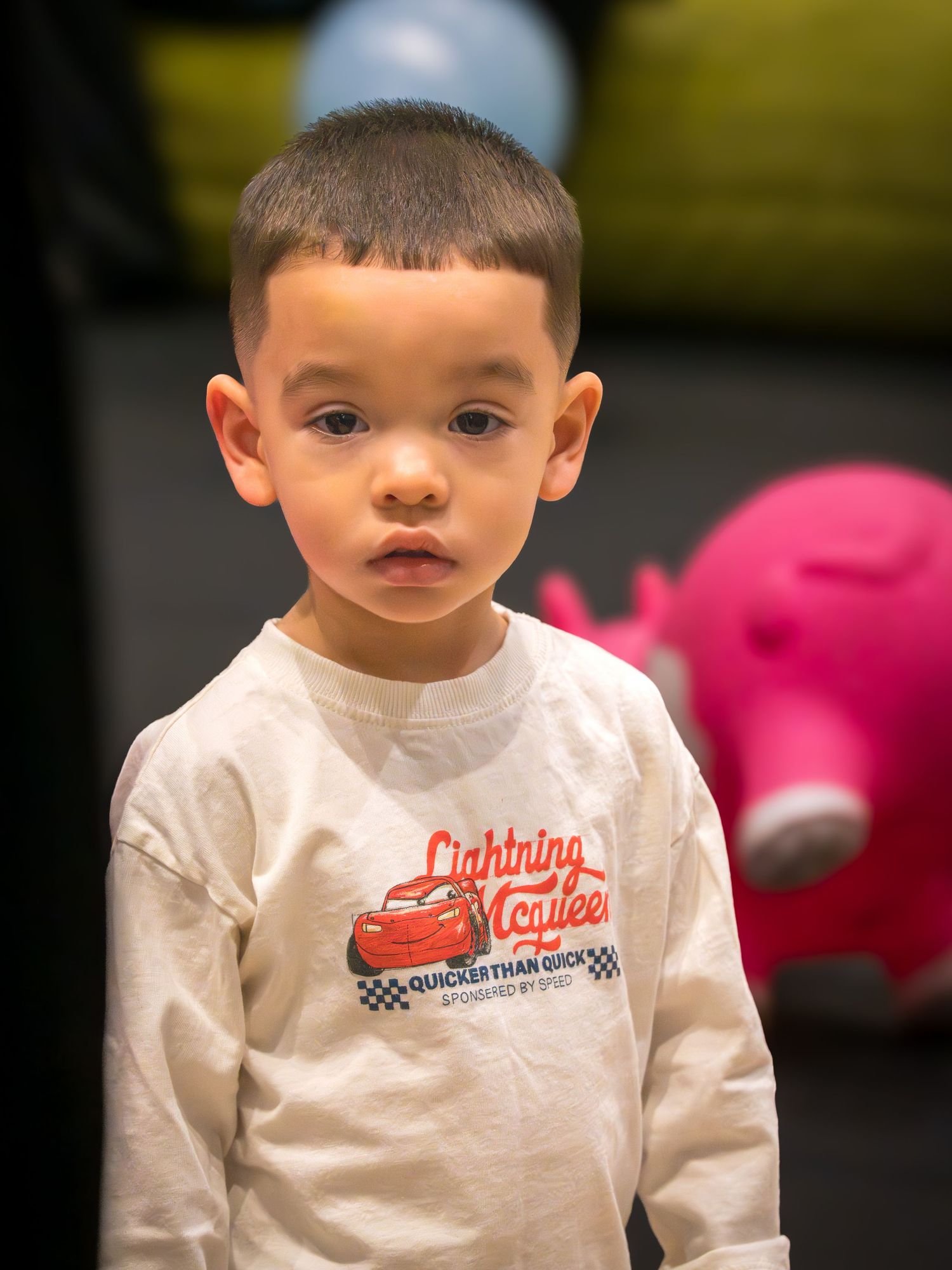 Young boy in Lightning McQueen shirt at an indoor play center.